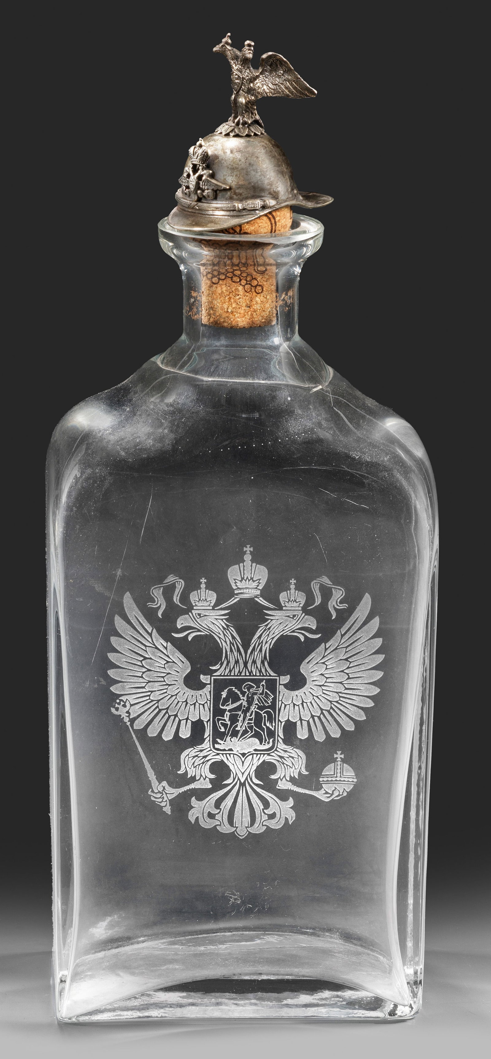 Wodkaflasche: Glas und Silber. Rechteckige Flasche aus farblosem Glas mit abgeflachten Ecken. Schauseitig geätztes Wappen des russischen Kaiserreichs mit Doppelkopfadler und Darstellung des heiligen Georgs als Dra