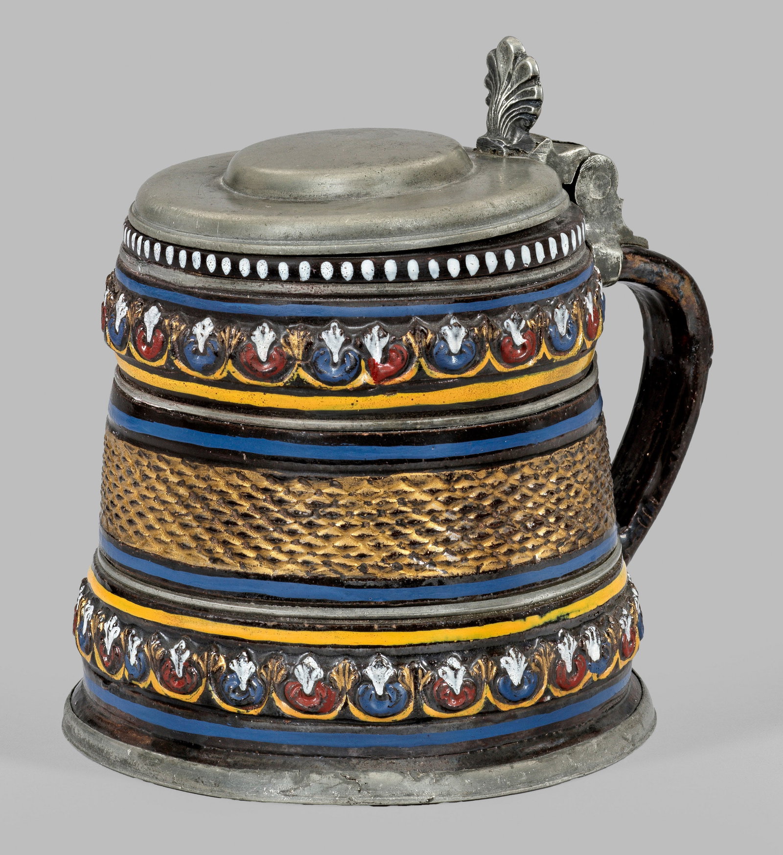 Walzenkrug aus Dippoldiswalde: Sog. Annaberger Steinzeug. Dunkelbraun engobiertes, salzglasiertes Steinzeug mit polychromer Emailbemalung. Auf der Wandung flächendeckender ornamentaler, teilw. vergoldeter Reliefdekor. Zinnmontieru
