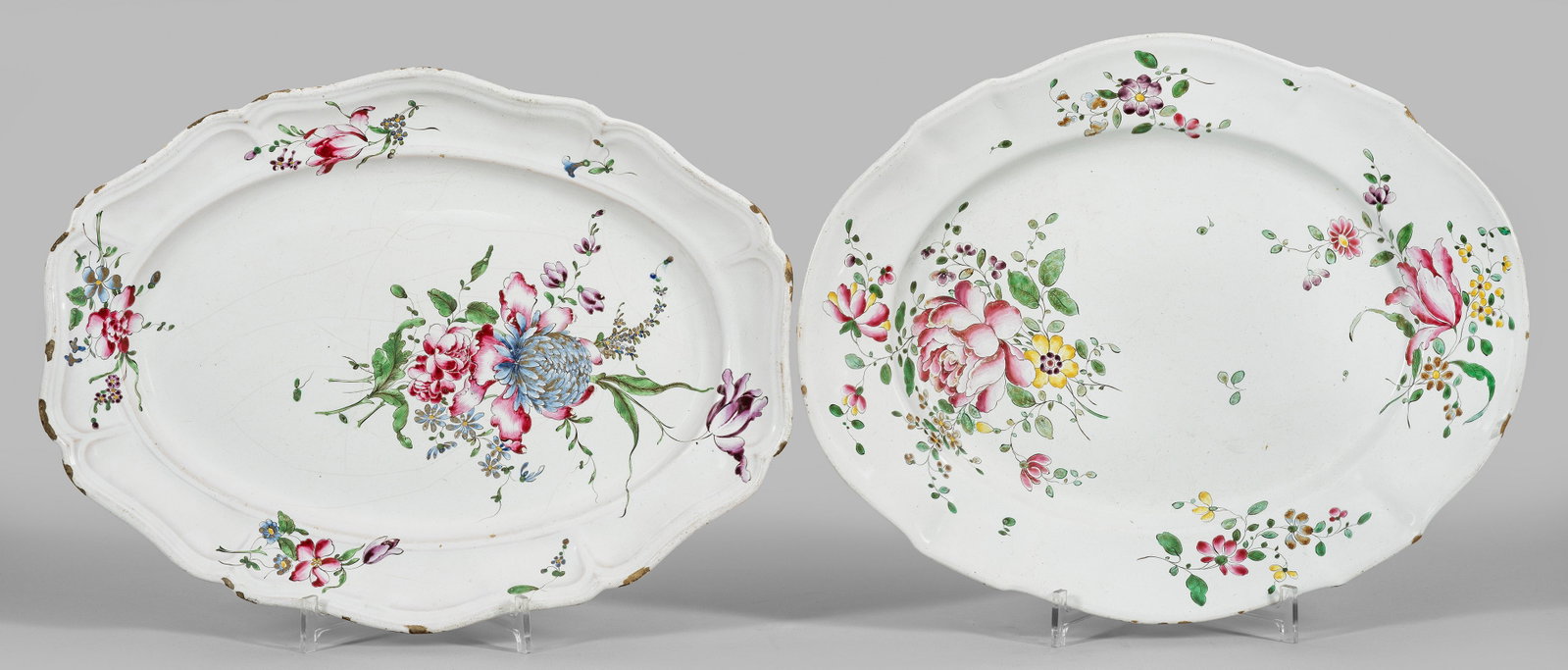 Zwei Straßburger Anbietplatten mit Blumendekor: Fayence. Ovale, leicht vertiefte Form mit fassonierter, geschweifter und gerippter Fahne. Im Spiegel und auf der Fahne Blumengebinde in polychromer Muffelmalerei. Glasurkrakelee. Partiell best.; Manuf
