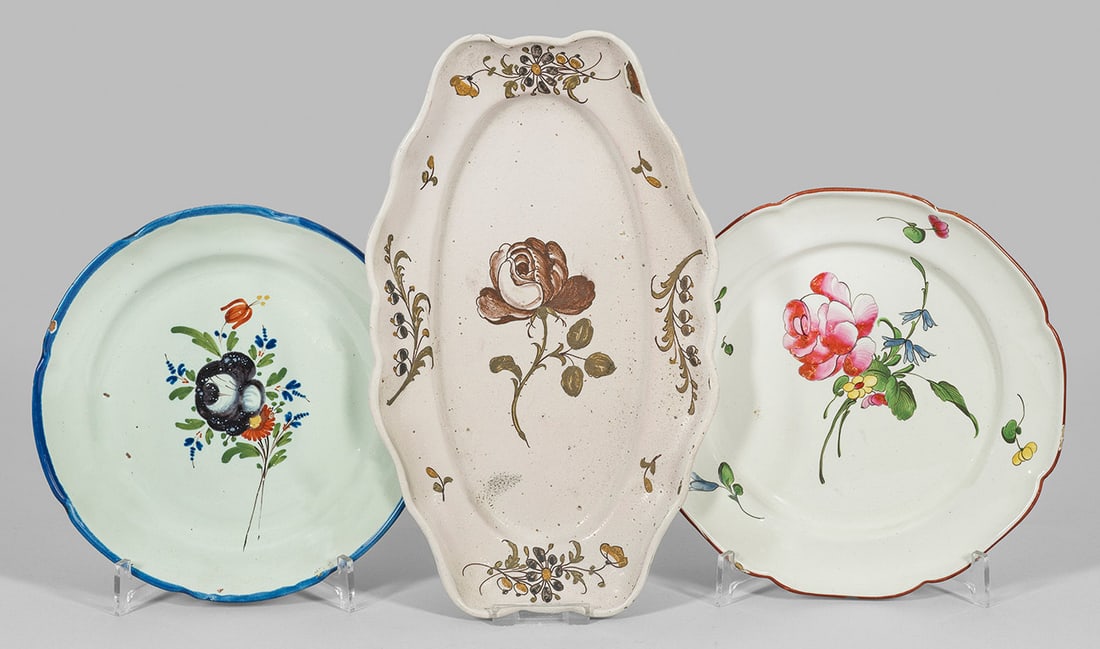 Zwei Teller und eine Anbietplatte: Fayence, heller Scherben. Runde bzw. ovale, passig geschweifte Form. Im Spiegel polychromer Blumendekor. Unw. best.; Teller-D. 22 cm - 24,5 cm. Platte 33 cm x 19 cm. Provenienz: Auflösung der Privats