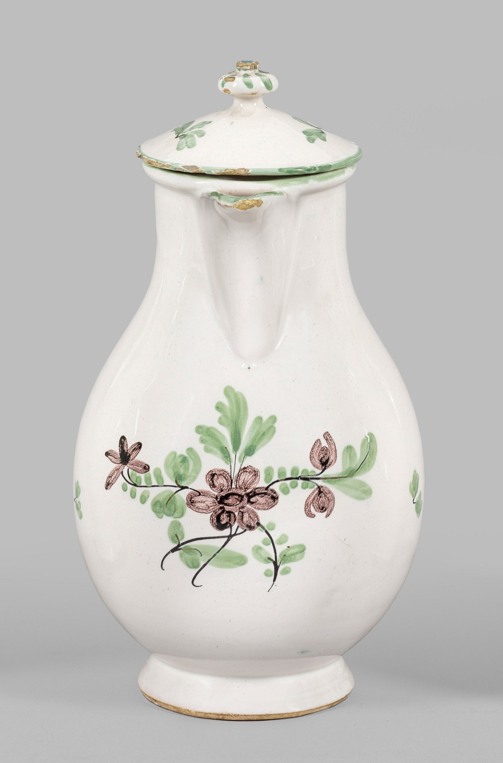 Durlacher Birnkanne mit Blumendekor: Fayence. Über dem Standring birnförmiger Korpus mit Ohrhenkel, konsolförmige Schnaupe sowie passig aufgewölbter Deckel mit gedrücktem Kugelknauf. Auf der Wandung Blüten in polychromer Scharffeue