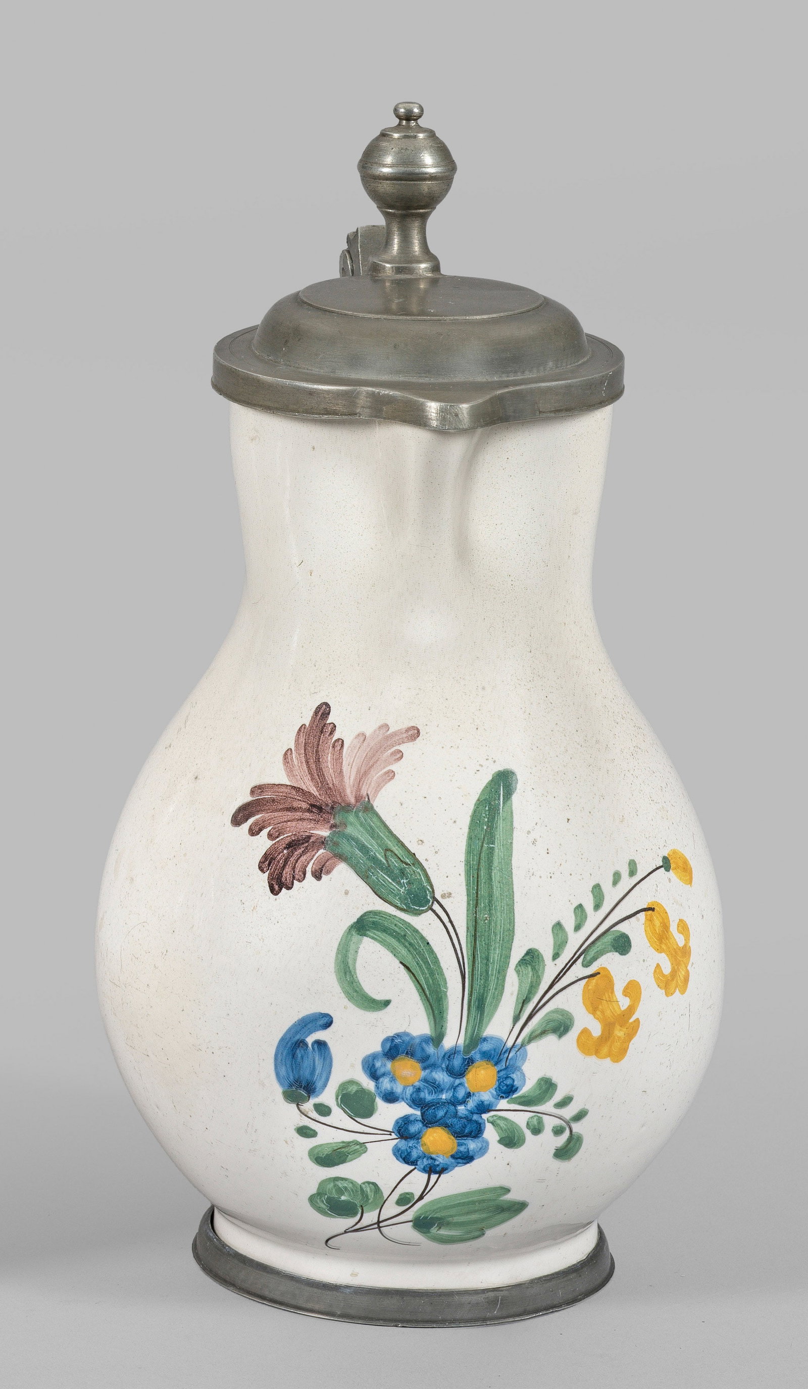 Mosbacher Birnkrug: Fayence. Balusterform mit seitlichem Bandhenkel. Auf der Wandung Blumengebinde in polychromer Malerei. Zinnmontierter Fußring und Deckel mit Kugelknauf. Rest.; Ges.-H. 23 cm. Provenienz: Auflösung d