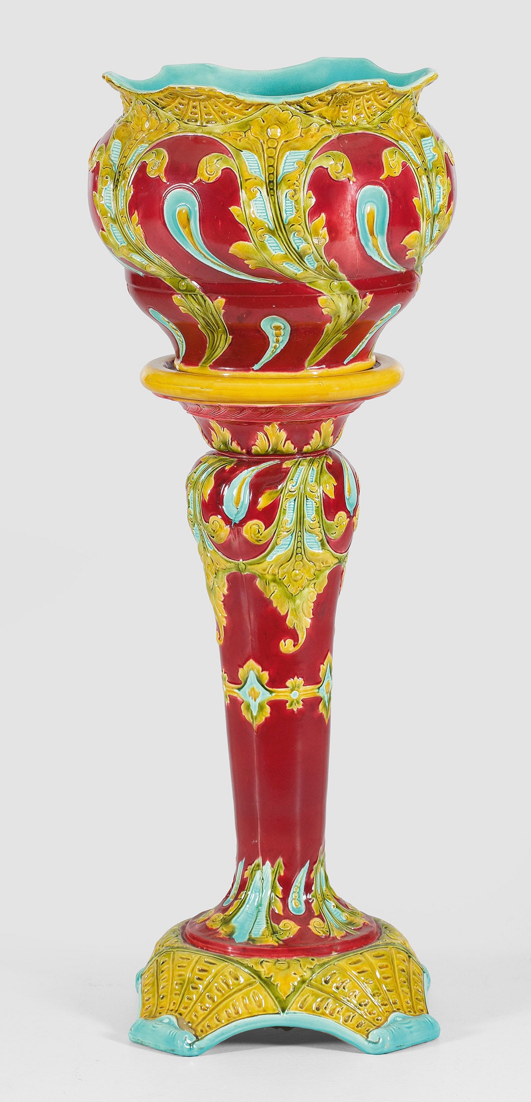 Belle Epoque-Cachepot: Majolika, mehrfarbig glasiert. Bombierter Korpus mit passig geschweiftem Lippenrand. Umlaufend der Wandung reicher, erhaben reliefierter Dekor aus üppigen Blattvoluten und Tropfenmotiven. Unterhalb k