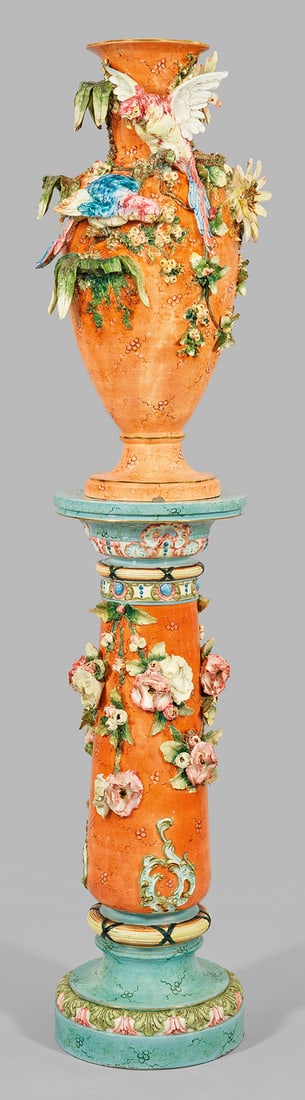 Große Belle Epoque-Bodenvase auf Sockel: Majolika, überwiegend ziegelfarbene, teilw. geäderte Glasur mit polychromer Malerei und Goldstaffage. Balusterform. Über profilierter Rundplinthe eiförmig gewölbter Korpus mit eingezogener Schult