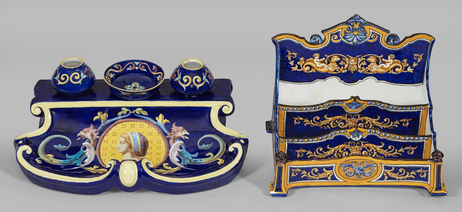 Briefgestell und Schreibzeug im Renaissance-Stil: Majolika und Fayence. Fabelwesen, Putten und Rankenwerk bzw. Rundbild mit Renaissance-Dame neben Drachenvoluten auf leuchtend blauem Fond. Polychrom staffiert. Sotheby's- und zwei alte Palais-Inventar
