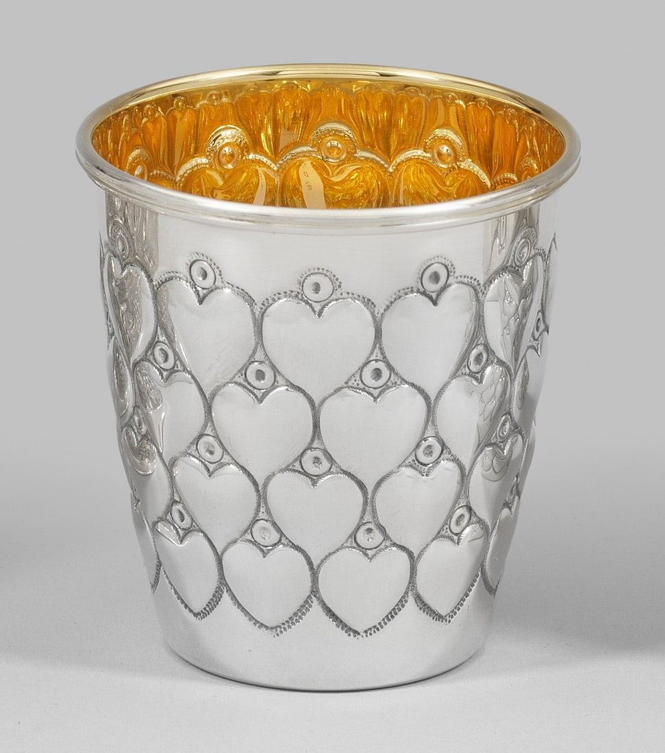 Herzbecher: Sterlingsilber. Gering konisch mit glattem Lippenrand. Wandung vierreihig versetzt umzogen von reliefplastischen Herzen. Innen vergoldet. Gest. 925. Gew. ca. 105 g. H. 8 cm. A German Sterling silver b