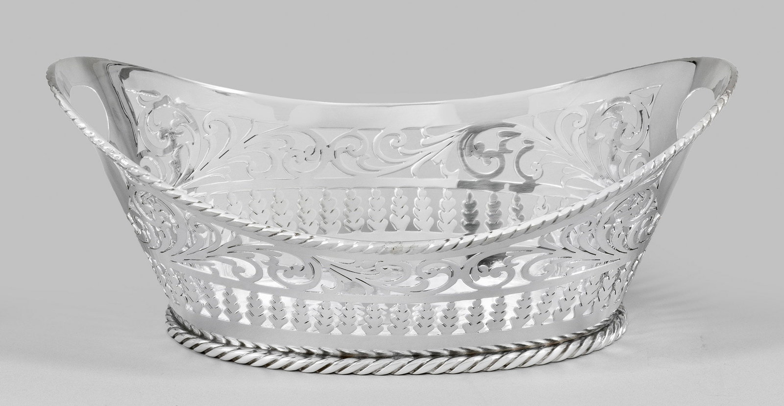 Dekorativer Brotkorb: Sterlingsilber. Über flachem Stand sich konisch erweiternde, floral und stabförmig durchbrochen gearbeitete Wandung mit Griffmulden. Gest. 925. Gew. ca. 320 g. H. 8,5 cm. 22 cm x 14 cm. A German Ste