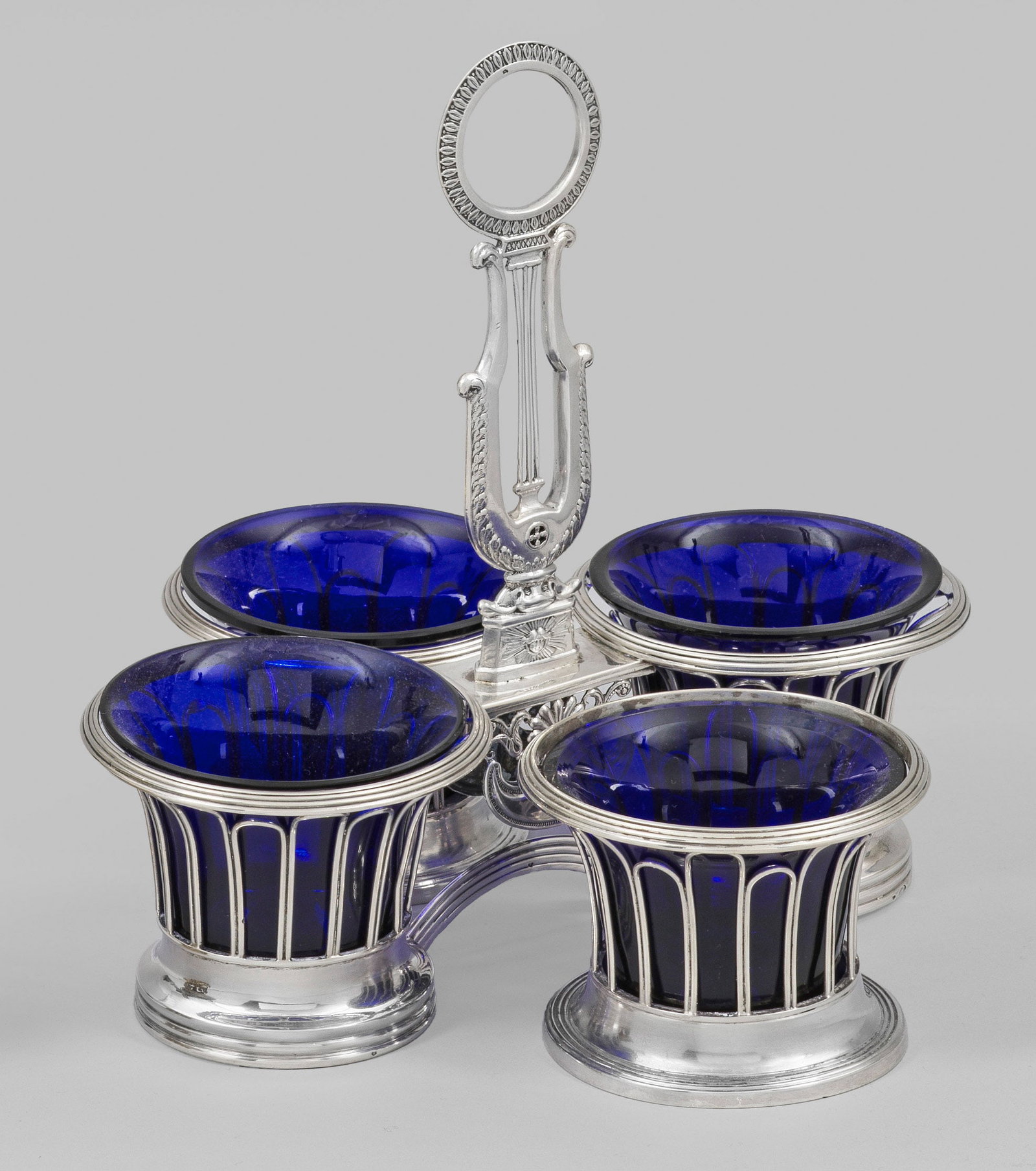Paar klassizistische Salieren und Doppelsaliere: Silber und kobaltblaues Glas. Runder, mehrfach profilierter Fuß und korrespondierender Rand, dazwischen durchbrochen gearbeitete Wandung. Verbindungsstück der Doppelsaliere mit Empire-Ornamenten und