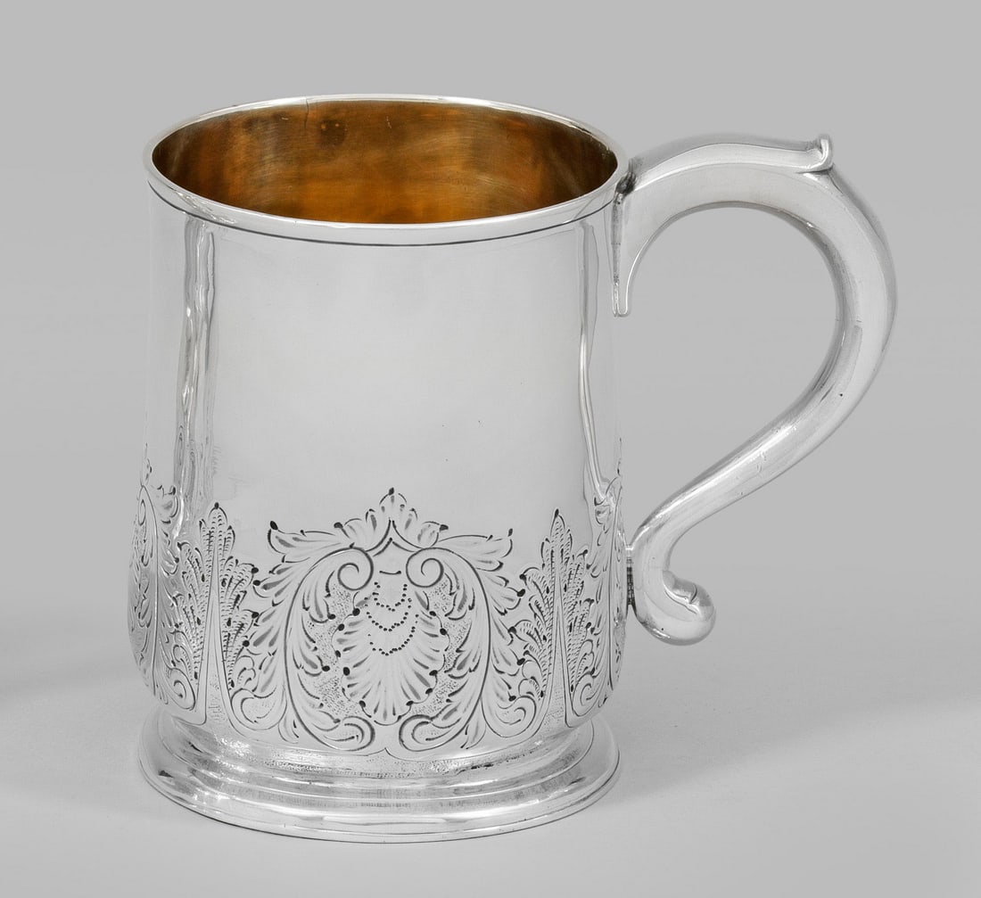George II-Henkelbecher: Sterlingsilber. Über ausgestelltem Rundfuß bauchiger, in der unteren Hälfte mit Blatt- und Rocaillegravuren umzogener Korpus mit profiliertem Rand. Volutierter Ohrenhenkel. Innen vergoldet. Gest. B