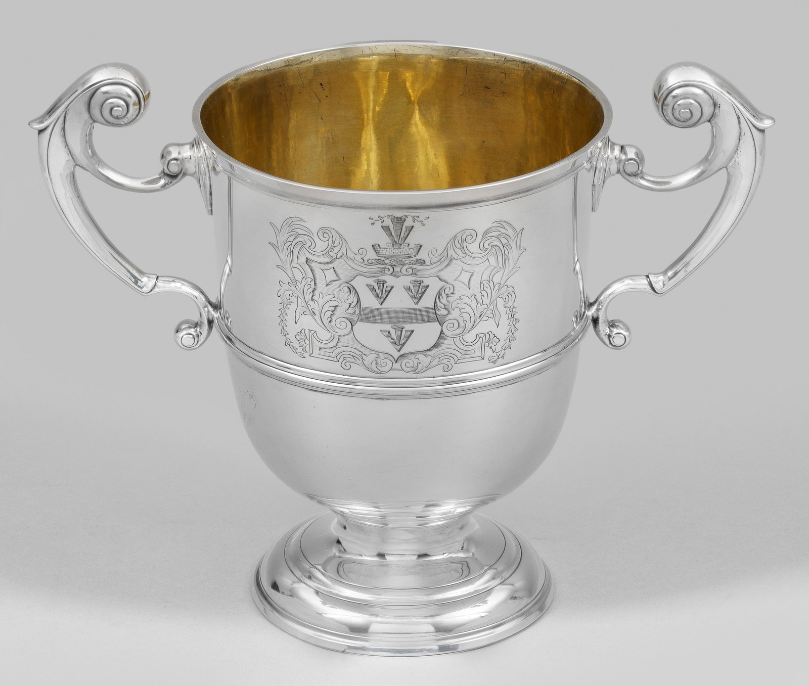 Georg II-Pokalvase: Sterlingsilber. Gering gestufter Rundfuß, übergehend in kurzen Schaft und konische Kuppa. Seitliche Volutenhenkel. Wandung mittig profiliert und schauseitig graviert mit Wappen unter Mauerkrone. Inn