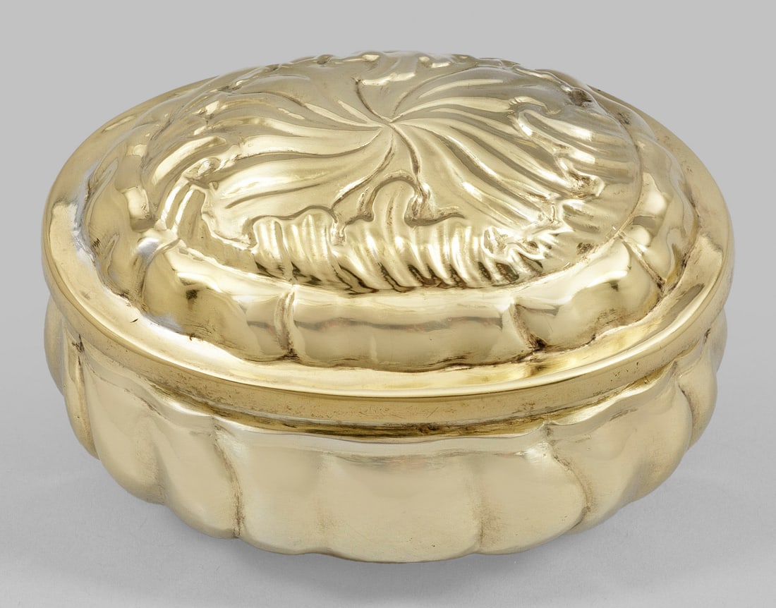 Kleine barocke Gewürzdose: Silber, voll vergoldet. Ovaler, flacher Stand übergehend in bauchigen Korpus mit Stülpdeckel. Wandung und Deckel umzogen von strahlenförmig angeordneten, passig wellenförmig geschweiften Zügen. M