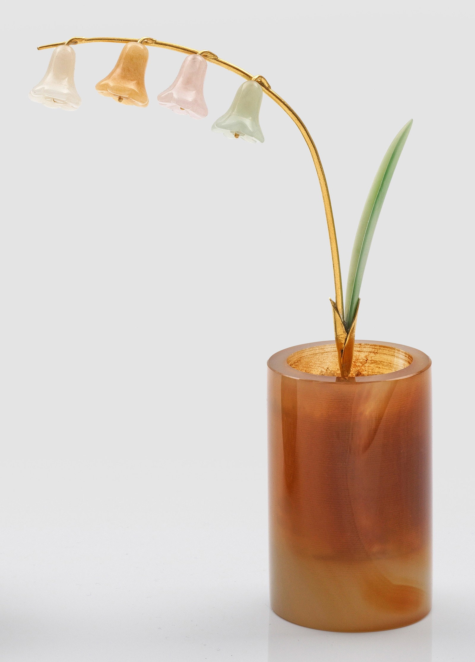 Kleiner Zier-Blumentopf: in der Art von Karl Fabergé. Halbedelsteine und Silber, vergoldet. Zylindrischer Topf aus honigbraunem Achat. Im Topf ein Maiglöckchen aus vergoldetem Silberdraht, besetzt mit geschliffenen Blüten 