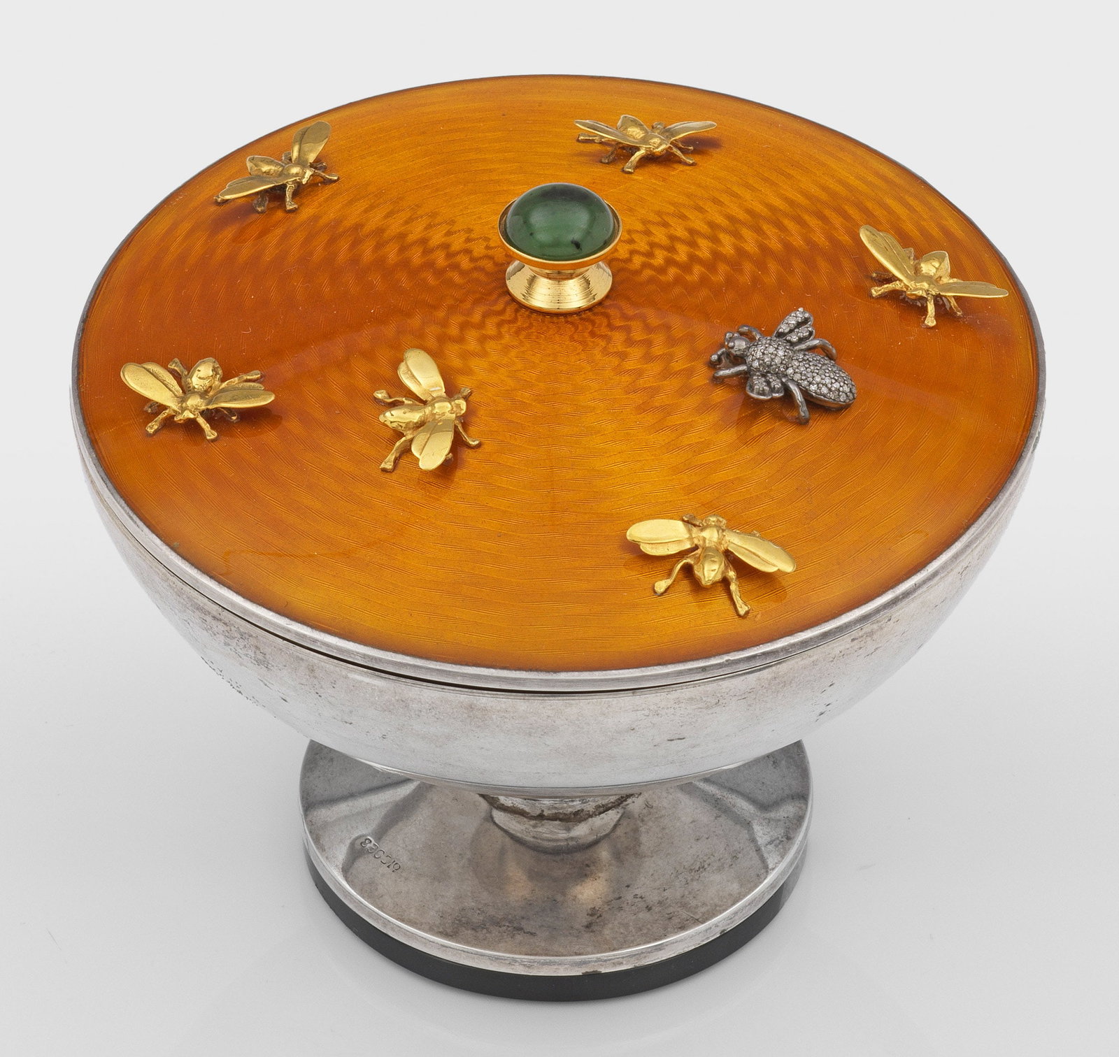 Kleine Aufsatz-Deckelschale: im Stil von Karl Fabergé. Silber, teilw. vergoldet und emailliert, Stein. Auf flachem, runden Steinsockel silberne Aufsatzschale mit eingezogenem Schaft und ausschwingender Kuppa. Der mittig leicht e