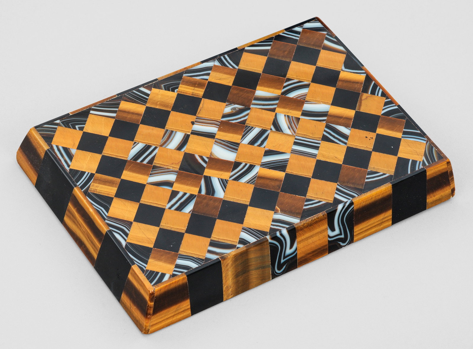 Art Déco-Briefbeschwerer: Schwere, rechteckige, nach oben leicht verjüngte Platte mit schachbrettförmig angeordneten Feldern aus Tigerauge und Achat. Best.; 16 cm x 11,5 cm x 2,5 cm. A French Art Deco tiger's eye and agate p