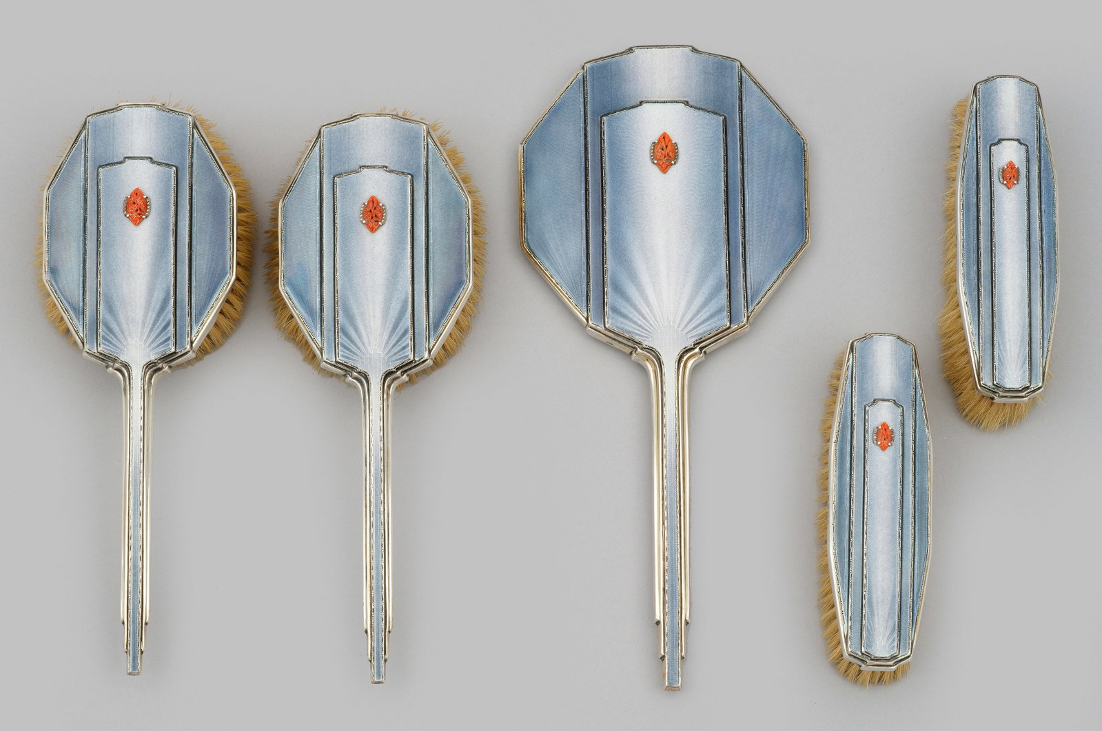 Georg V-Toiletteset: 5-tlg.; Sterlingsilber, teilw. emailliert, Holz und Borsten. Zwei Haarbürsten, zwei Kleiderbürsten und ein Handspiegel. Rückseiten mehrfach profiliert, wellen- bzw. strahlenförmig guillochiert, si