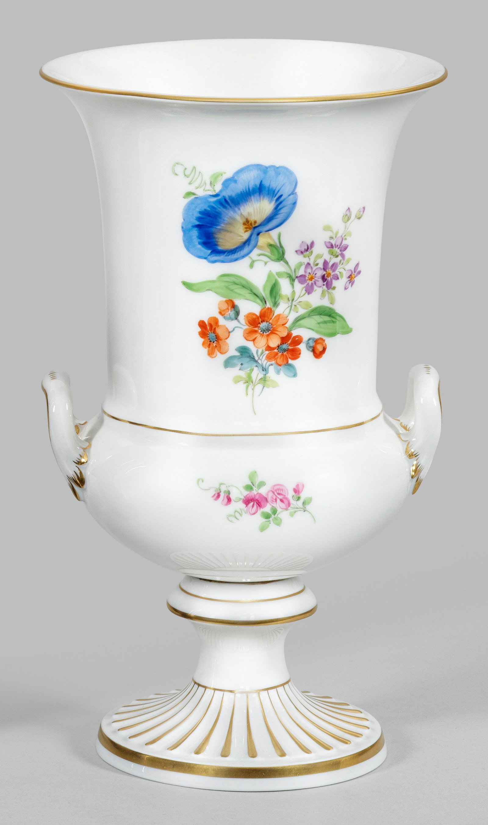 Kratervase mit Blumendekor: Über kanneliertem Rundfuß gedrückt bauchiger Korpus mit abgesetztem, zylinderförmigem Hals, in weit ausschwingender Mündung endend. Seitlich blattreliefierte Henkel. Schauseitiges Blumengebinde m