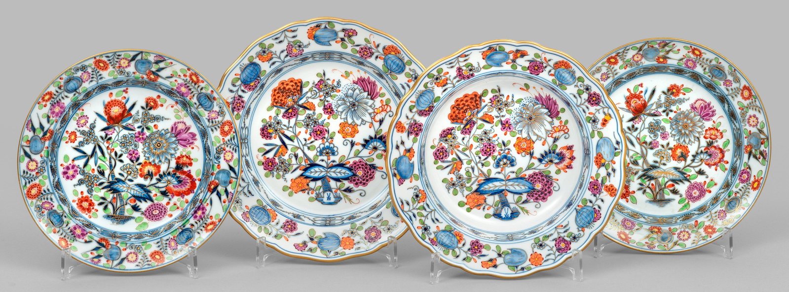 Vier Teller mit Dekor "Zwiebelmuster Royal bunt": Verschiedene Formen mit glatter und geschweifter Fahne. Zwiebelmusterdekor in unterglasurblauer Malerei, überdekoriert in Eisenrot, Purpur, Grün, wenig Gelb und Gold. Partiell minim. best.; Schwerte