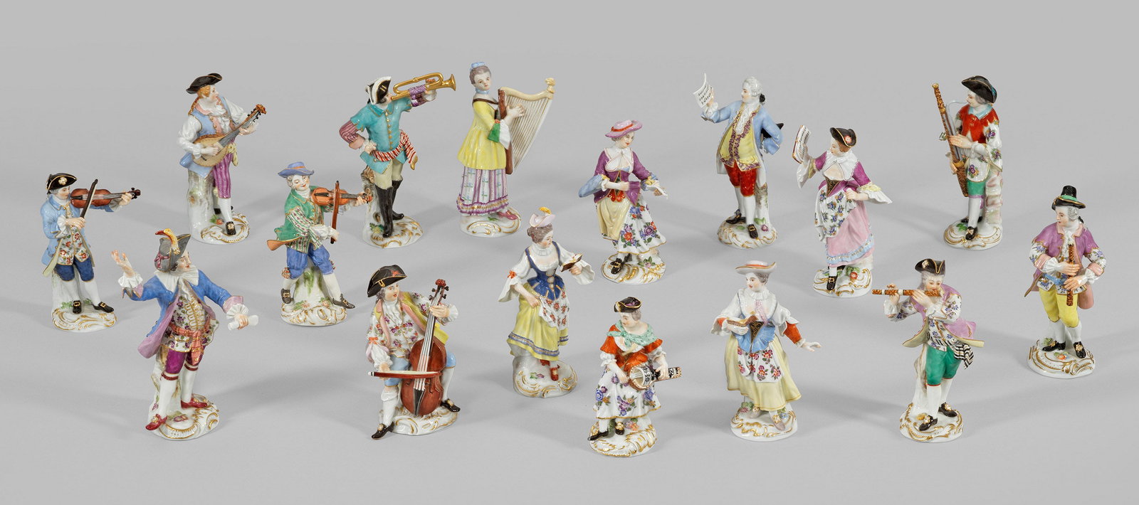 Sammlung von 16 Meissen Figuren aus der Serie: "Galante Kapelle" Auf rocaillereliefiertem Sockel stehender Dirigent, Harfenspielerin, 2 Geiger, Cellist, Fagotist, Flötist, Trompeter, Drehleierspielerin, Lautenspieler, Klarinettist und 5 Sängerin