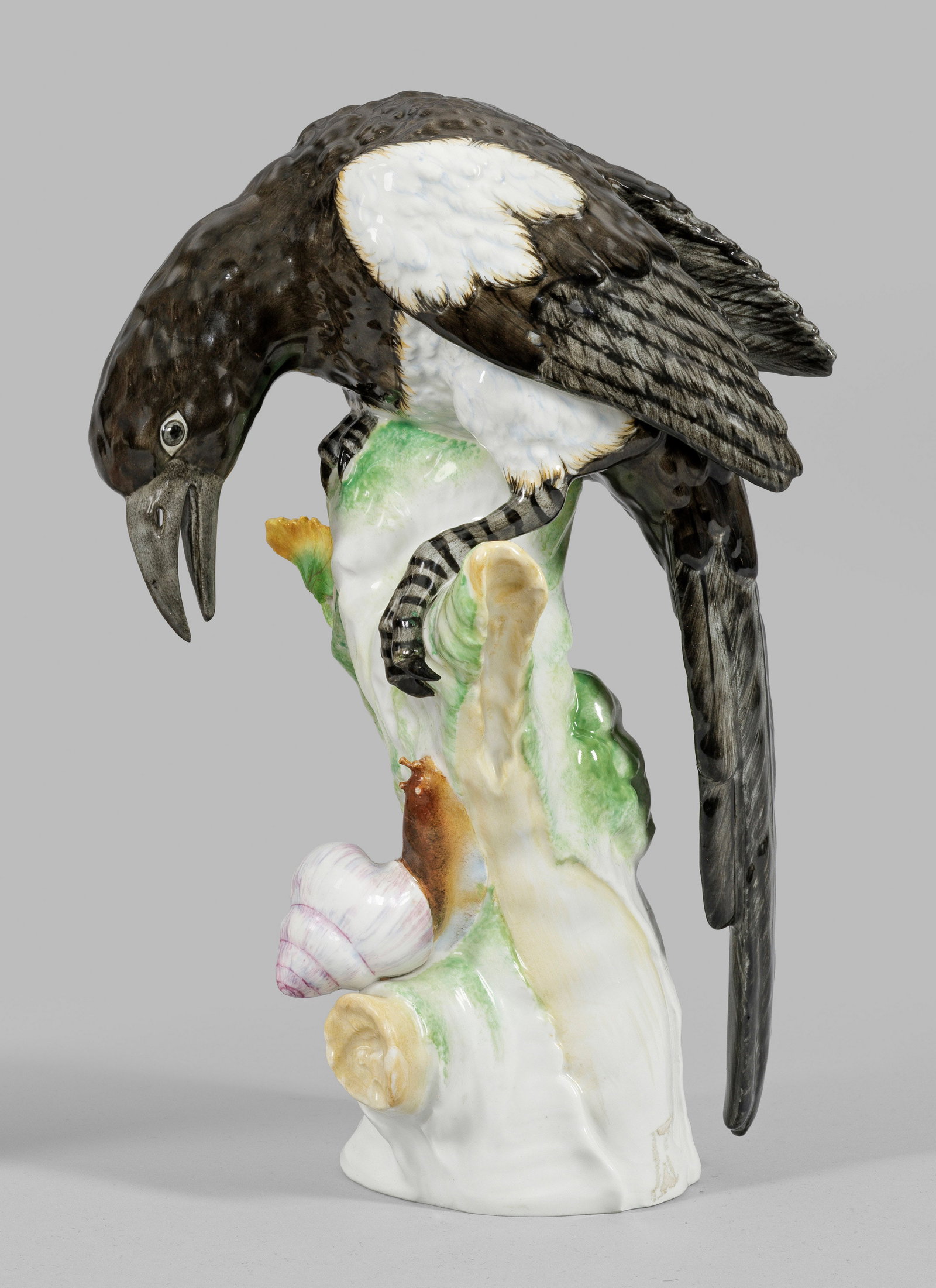 Elster mit Schnecke: Auf hohem Baumstamm sitzende Elster mit langem Gefieder, eine sich empor bewegende Schnecke betrachtend. Polychrome Malerei. Entw. Johann Baptist Pedrozzi. Minim. best.; Zepter- und Malereimarke. H. 2