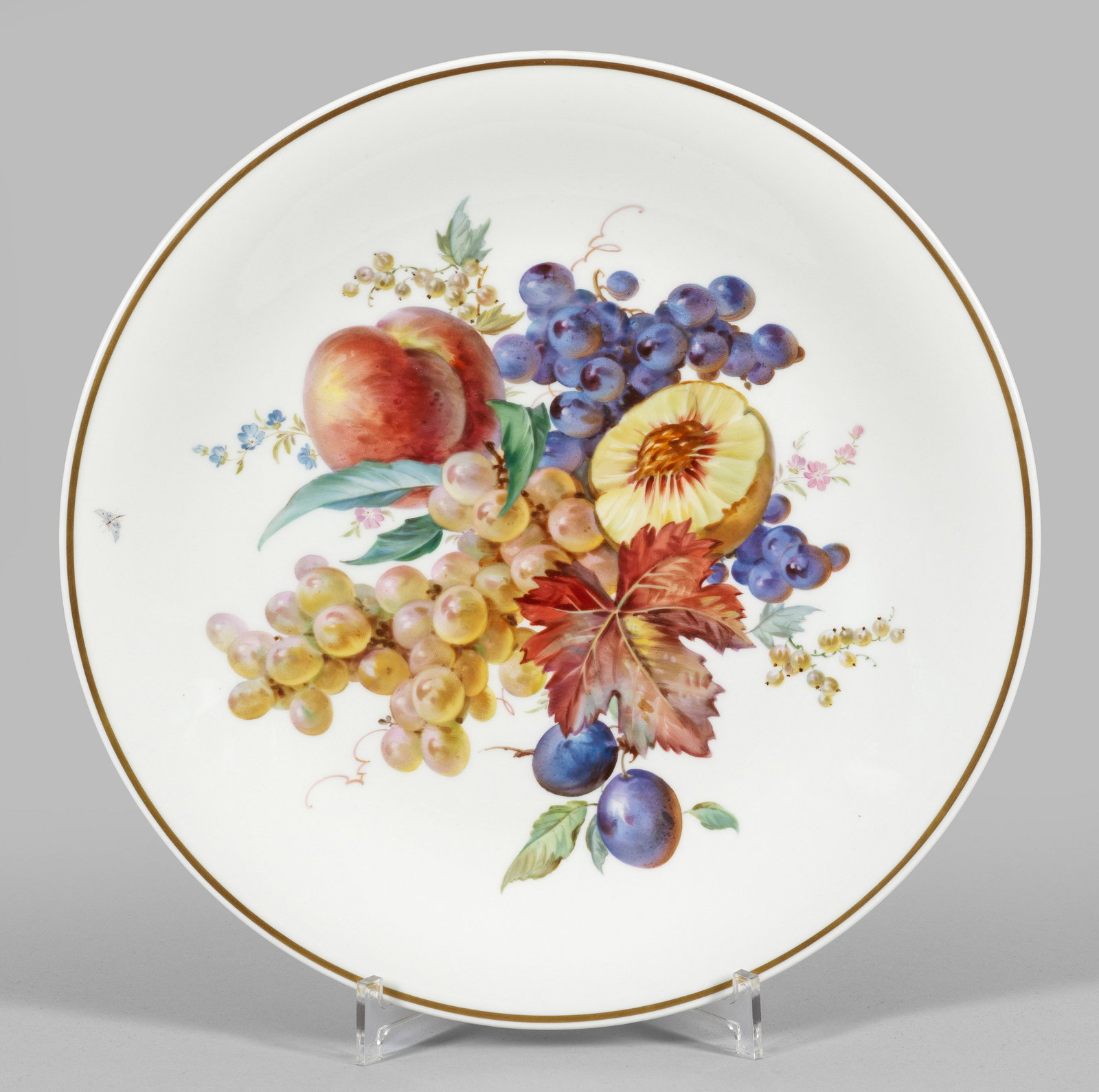 Großer Wandteller mit Früchtedekor in der Art von: Prof. Julius Eduard Braunsdorf Runde, flach gemuldete Form. Im Spiegel großflächig angelegtes Früchtearrangement u.a. aus hellen und dunklen Trauben in weicher, polychromer Malerei. Goldrand. Rück
