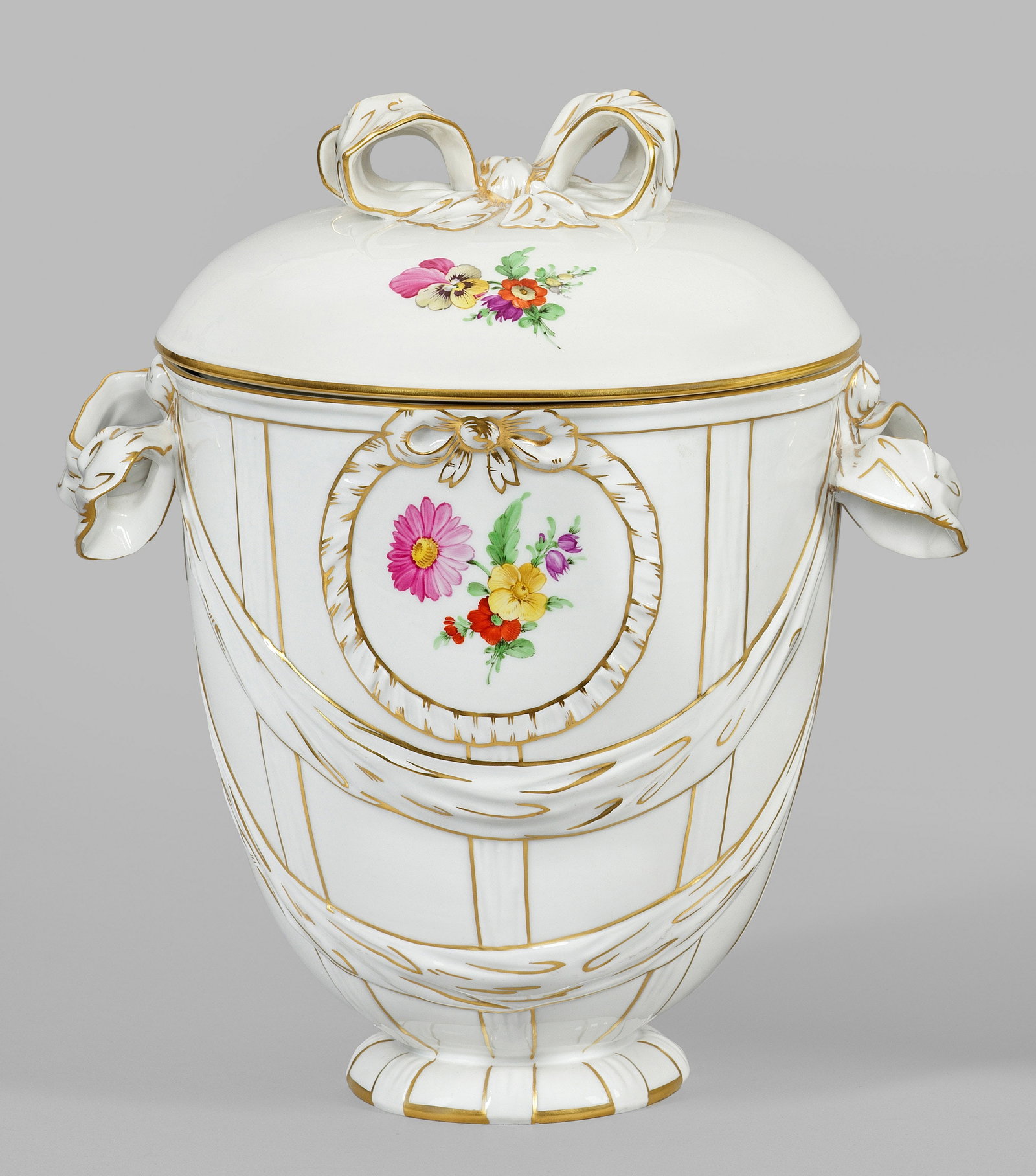Deckelvase mit Blumendekor: sog. "Bandschleifen-Potpourri". Rundstand mit eiförmig aufgewölbtem Korpus. Oberhalb schleifenbekrönte Medaillons mit Blumengebinden. Seitliche Handhaben und Bekrönung des Deckels in Gestalt gebun