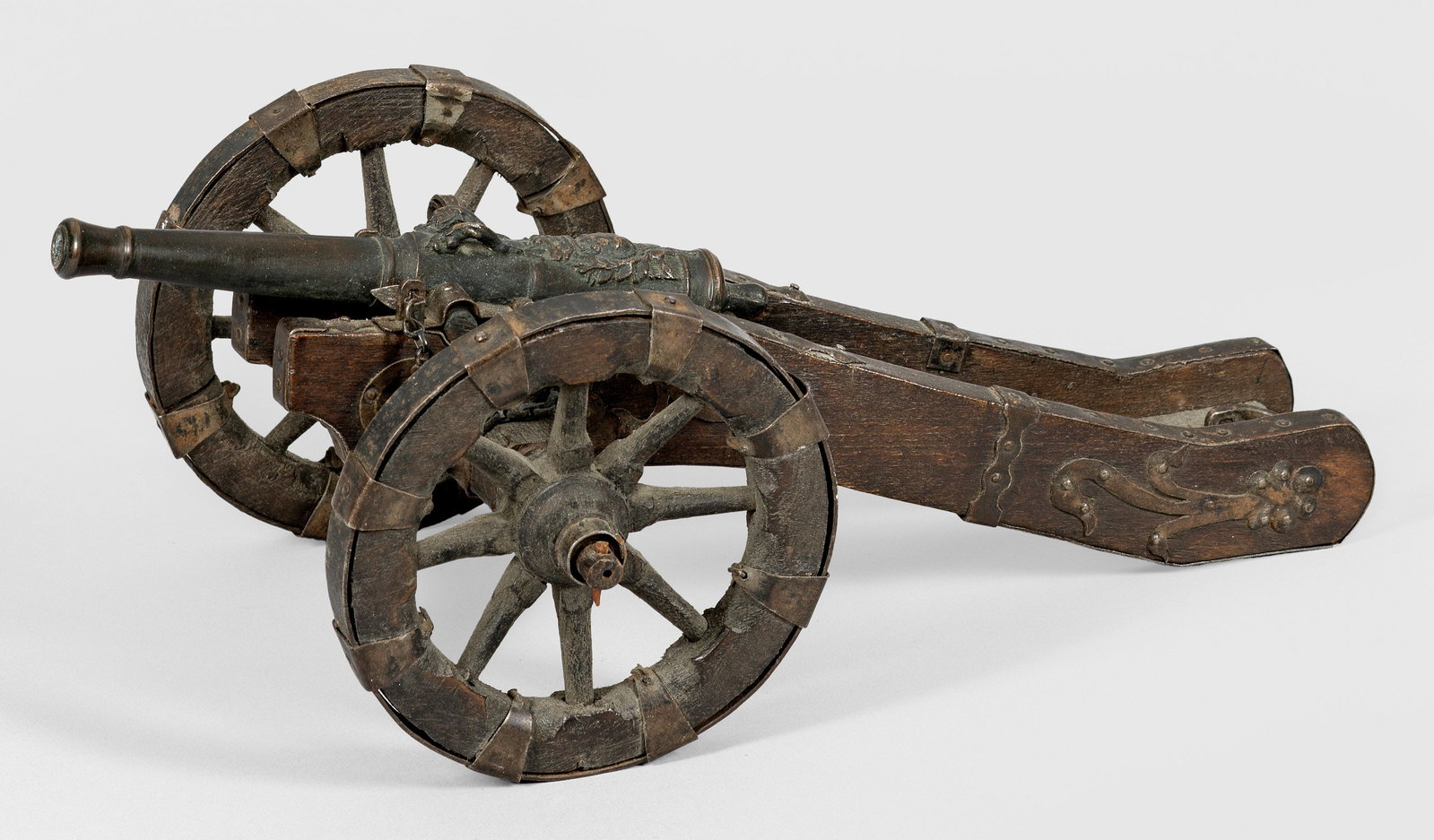Miniatur-Feldschlange: Eisen, Bronze und Holz. Naturalistisch nachgebaute Kanone mit bronzenem Rohr auf hölzerner Lafette mit zwei achtspeichigen Rädern und Eisenbeschlägen. Der Lauf an der Oberseite reliefiert mit dem W
