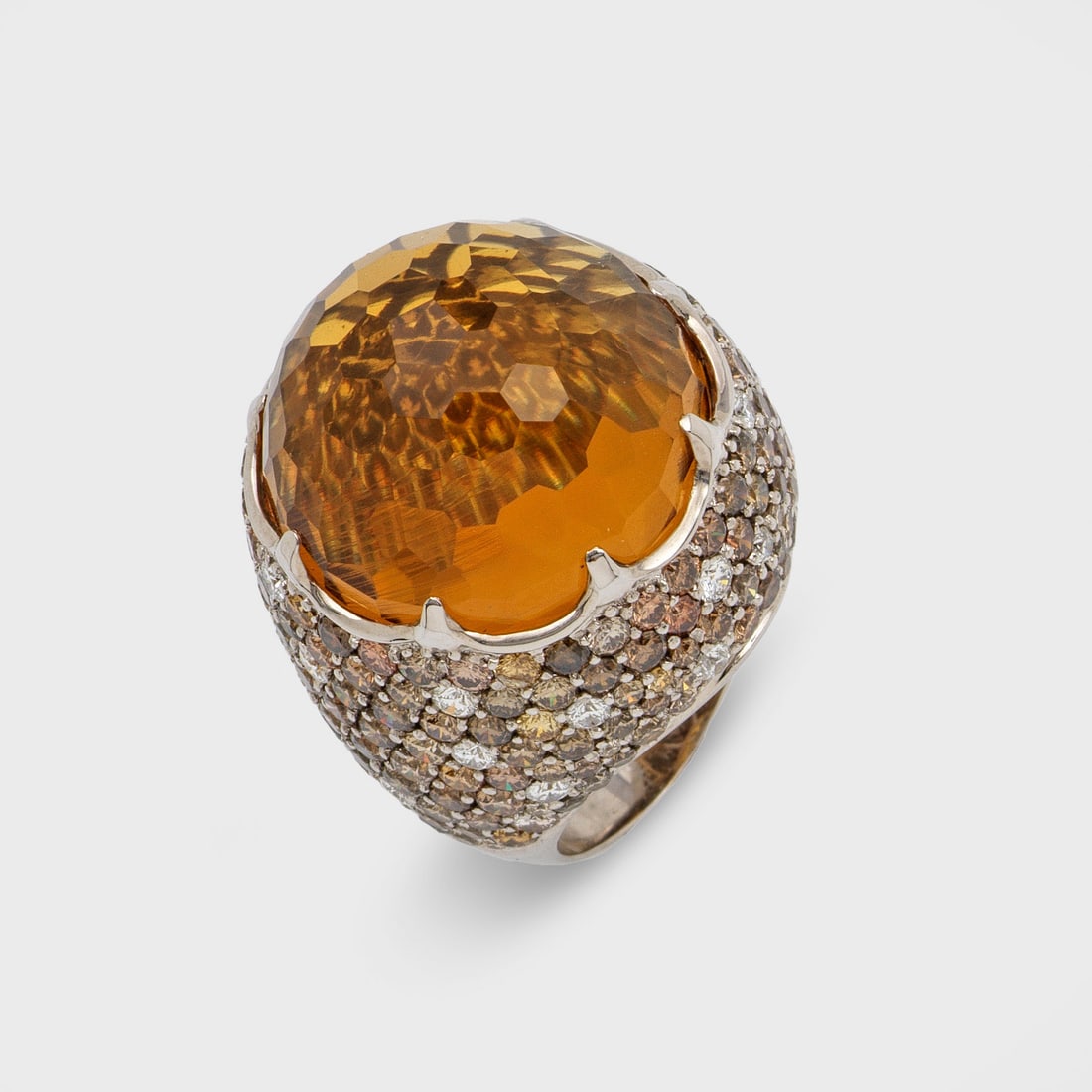 Glamouröser Citrinring: Weißgold, gest. 750. Zentral besetzt mit einem goldgelben Citrin von ca. 29,60 ct., umrahmt von kleinen Citrinen von zus. ca. 6,80 ct. und Diamanten von zus. ca. 0,91 ct., in Pavéfassung. Gew. ca. 2