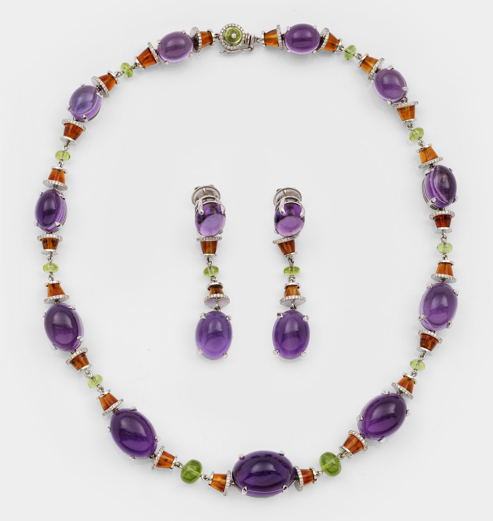Extravagantes Demi Parure mit Amethysten im Stil von BVLGARI: Weißgold, gest. 14 ct.; Collier und korrespondierendes Paar Ohrgehänge. Besetzt mit fliederfarbenen Amethyst-Cabochons von zus. ca. 304,43 ct., apfelgrünen Peridots von zus. ca. 17,59 ct. und orang