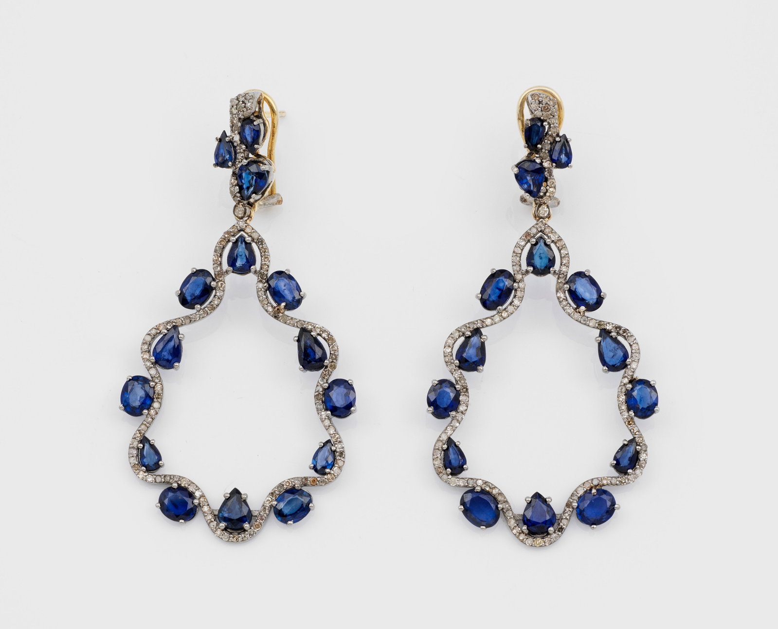 Paar elegante Saphir-Ohgehänge im viktorianischen Stil: Silber, Gelbgold, teilw. 14 ct.; Schauseitig besetzt mit tintenblauen bis nahezu kornblumenblauen Saphiren von zus. ca. 6,00 ct., akzentuiert durch kleinen Diamanten. Ges.-Gew. ca. 12,78 g. Pair of ea