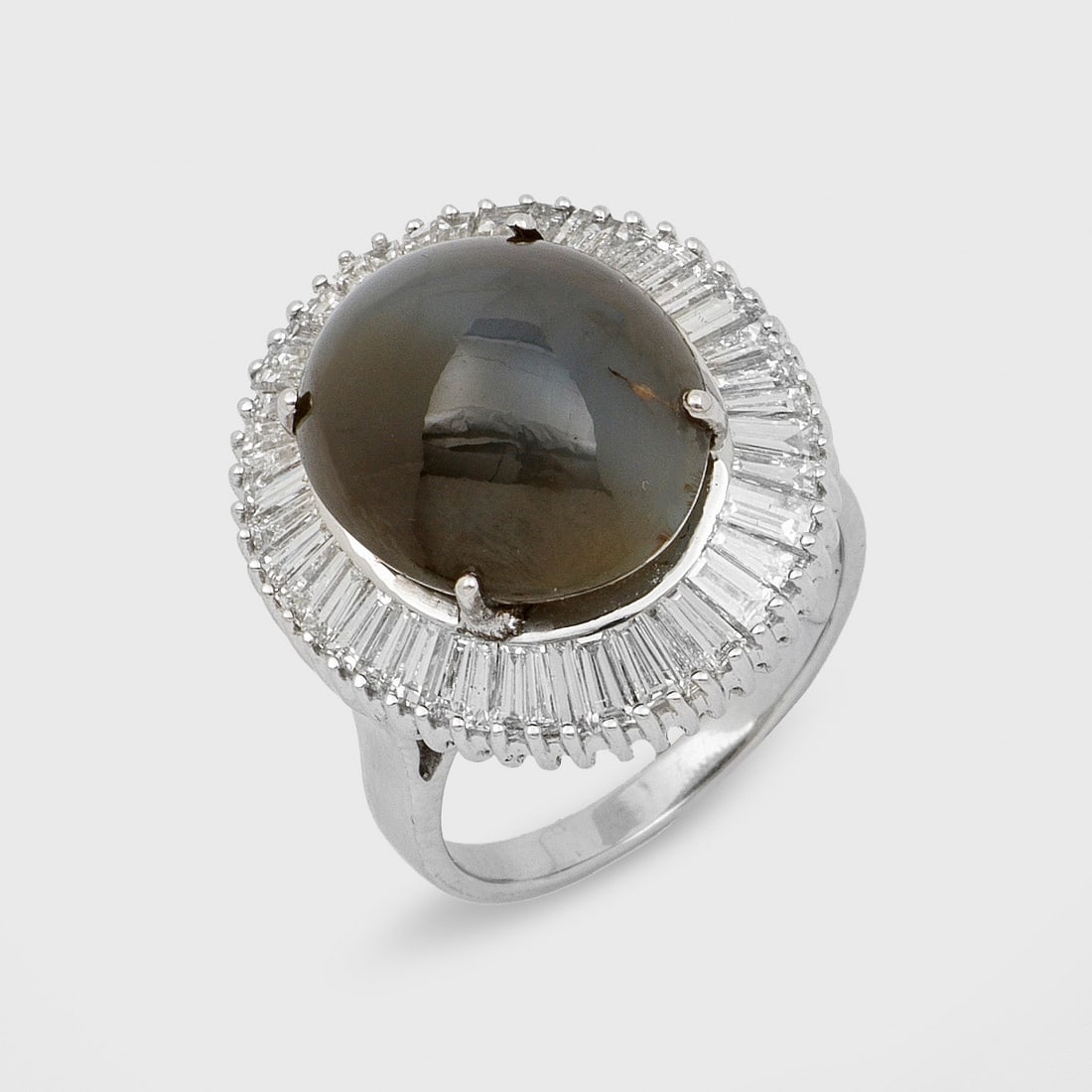 Eleganter Diamant-Entouragering mit Tigerauge: Weißgold, gest. 750. Zentral besetzt mit einem unbehandelten Tigeraugen-Cabochon von ca. 13,43 ct., entouriert von Diamant-Trapezen von zus. ca. 2,80 ct. (H/vs). Gew. ca. 11,74 g. Beiliegend GRS-Expe
