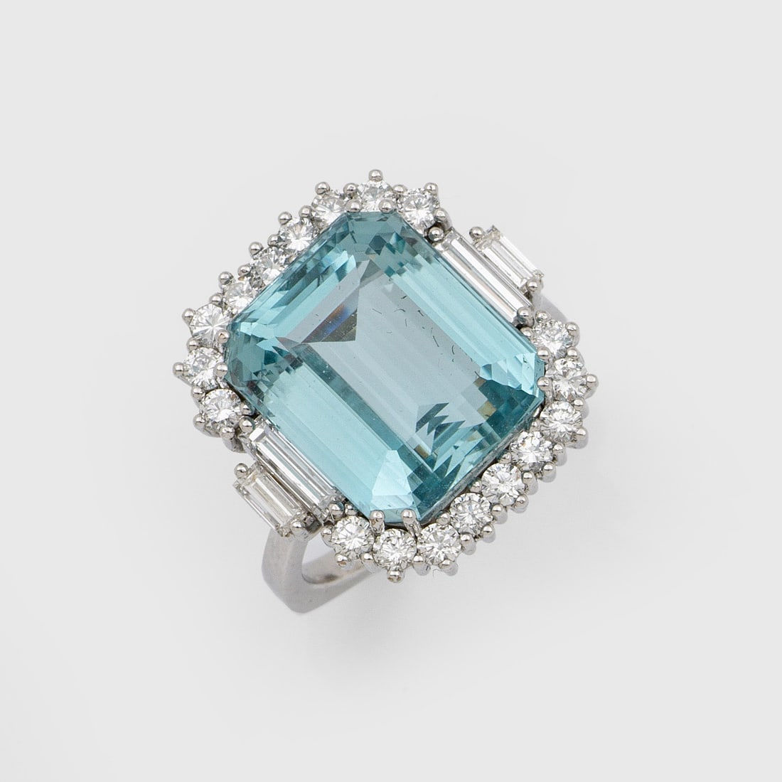 Hochfeiner Aquamarin-Brillantring: Weißgold, gest. 750. Zentral besetzt mit einem himmelblauen Aquamarin von ca. 14 x 12 x 8 mm, entouriert von Brillanten von zus. ca. 0,60 ct. (G-H/vs-si) und 2 Diamant-Baguetten von zus. ca. 0,16 ct.