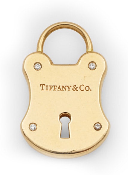 Schloß-Anhänger mit Brillanten von Tiffany & Co.: Roségold, gest. 750. Plastisch gestaltetes Schloß, besetzt mit vier kleinen Brillanten. Herstellerzeichen. Original Beutel. Gew. ca. 12,55 g. Lock pendant by Tiffany & Co., set with small diamonds, 