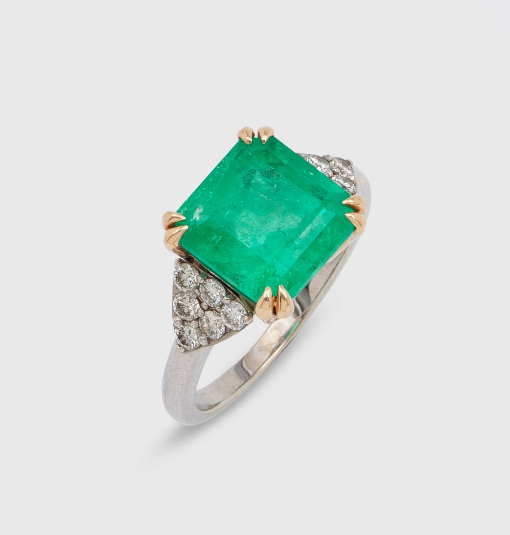 Kolumbianischer Smaragdring: Weißgold, gest. 750. Zentral besetzt mit einem leuchtendgrünen (moderate) Smaragd von ca. 4,97 ct , flankiert von Brillanten von zus. ca. 1,20 ct.; Gew. ca. 6,15 g. Beiliegend SSEF-Expertise, Nr. 15
