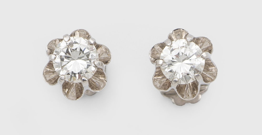 Paar klassische Brillantsolitär-Ohrringe: Weißgold, gest. 585. Zentral besetzt mit 2 Brillanten von zus. ca. 0,90 ct. (H-I/vs), in Kronenfassung. Ges.-Gew. ca. 3,11 g. Pair of earrings set with 2 brilliant solitaires approx. 0,90 ct. (H-I/vs