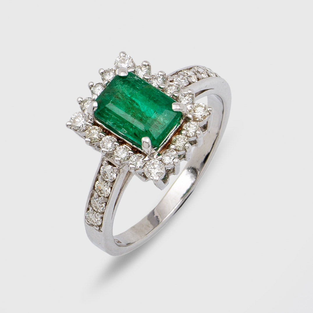 Eleganter Brillant-Entouragering mit Smaragd: Weißgold, gest. 585. Zentral besetzt mit einem Smaragd von ca. 1,50 ct., entouriert von Brillanten von zus. ca. 0,80 ct.; Gew. ca. 3,70 g. Ring set with an emerald approx. 1,50 ct. and diamonds appro