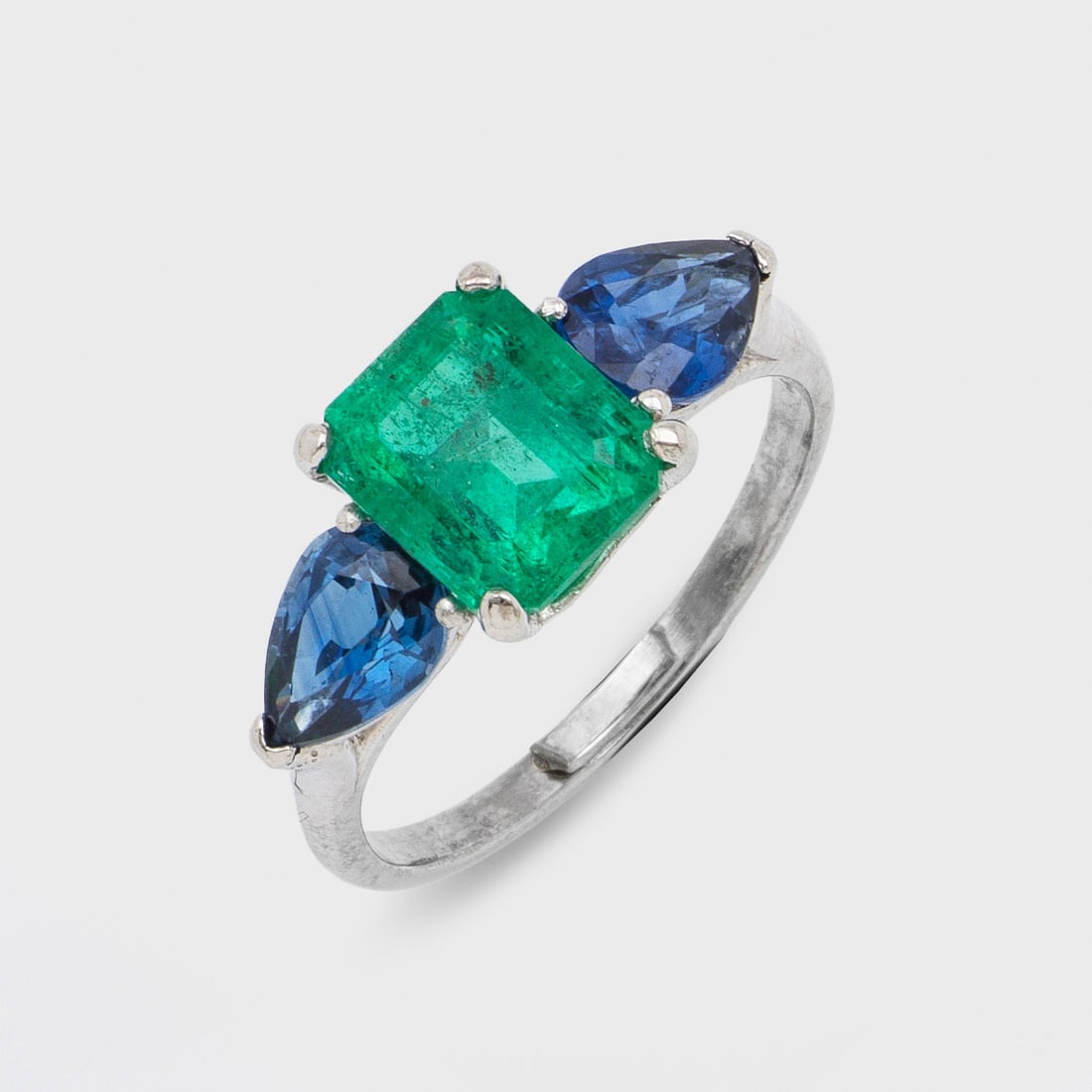 Klassischer kolumbianischer Smaragdring mit Saphiren: Platin, gest. 950. Zentral besetzt mit einem leuchtendgrünen Smaragd von ca. 3,0 ct., flankiert von 2 nahezu kornblumenblauen Saphiren von ca. 2,50 ct. im Tropfenschliff. Gew. ca. 6,20 g. Ring set wi