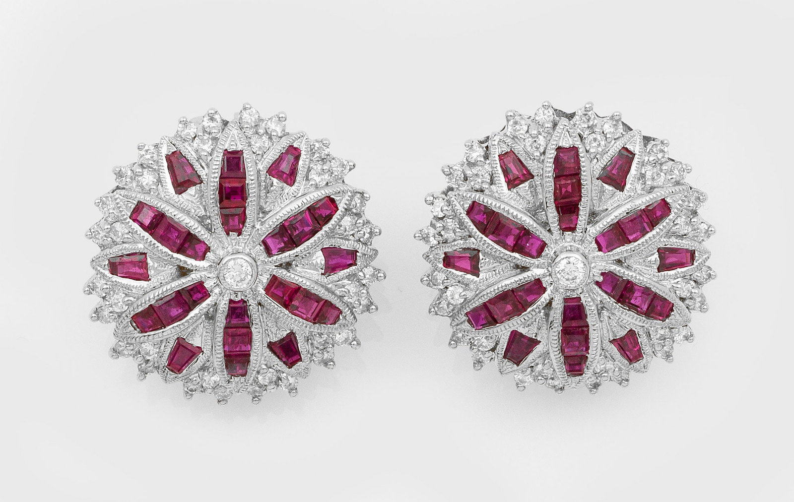 Paar elegante Rubin-Diamant-Ohrclips: Weißgold, gest. 18 ct.; Gestaltet in Form einer Blattrosette, ausgefasst mit taubenblutroten Rubin-Carrées und kleinen Diamanten. Ges.-Gew. ca. 17,53 g. Pair of earclips set with pigeon blood red ru