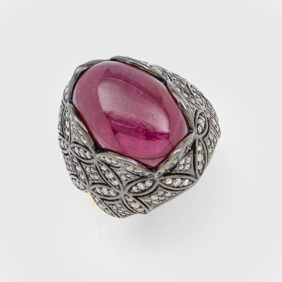 Extravaganter Rubin-Diamantring: Gelbgold, 14 ct. und Silber. Ringkopf aus floralem Gitterwerk in Ajour, ausgefasst mit kleinen Altschliffdiamanten von zus. ca. 1,25 ct., zentral besetzt mit einem taubenblutrotem Rubin-Cabochon von c