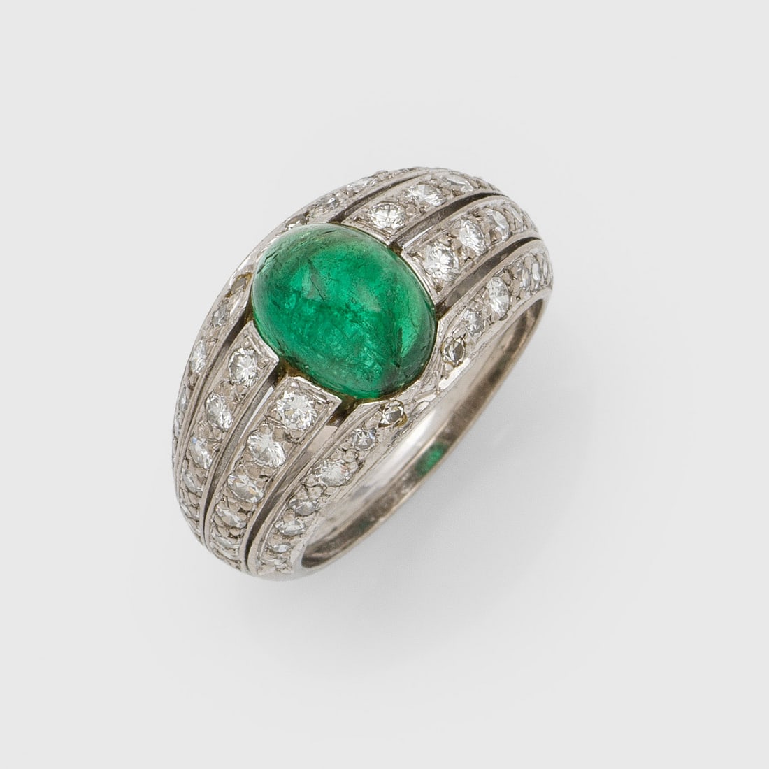 Klassischer Brillant-Bandring mit Smaragd: Weißgold, gest. 750. Zentral besetzt mit einem Smaragdcabochon von ca. 2,00 ct. und Brillanten sowie 8/8 Diamanten von zus. ca. 1,00 ct.; Gew. ca. 8,86 g. Ring set with an emerald approx. 2,00 ct. an