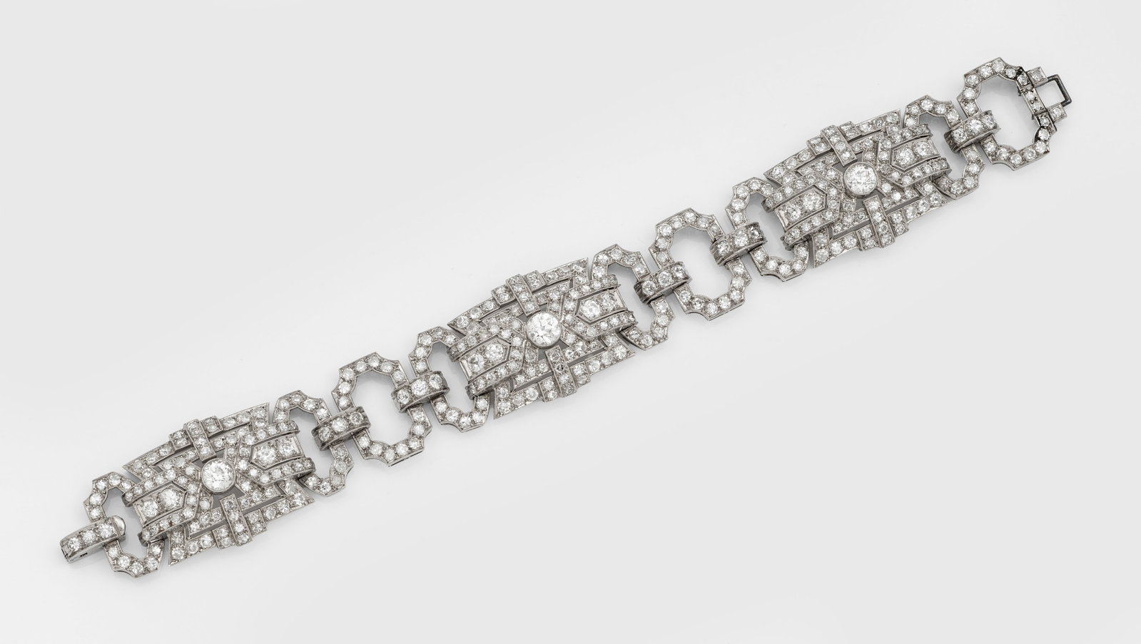 Glamouröses Art Déco-Diamantarmband: Platin. Breite Bandform aus geometrisch gestalteten Gliedern in Ajour, ausgefasst mit Altschliffdiamanten von zus. ca. 12,00 ct., umzogen von feinen Millgriffbändern. Gew. ca. 49,63 g. Bracelet set w