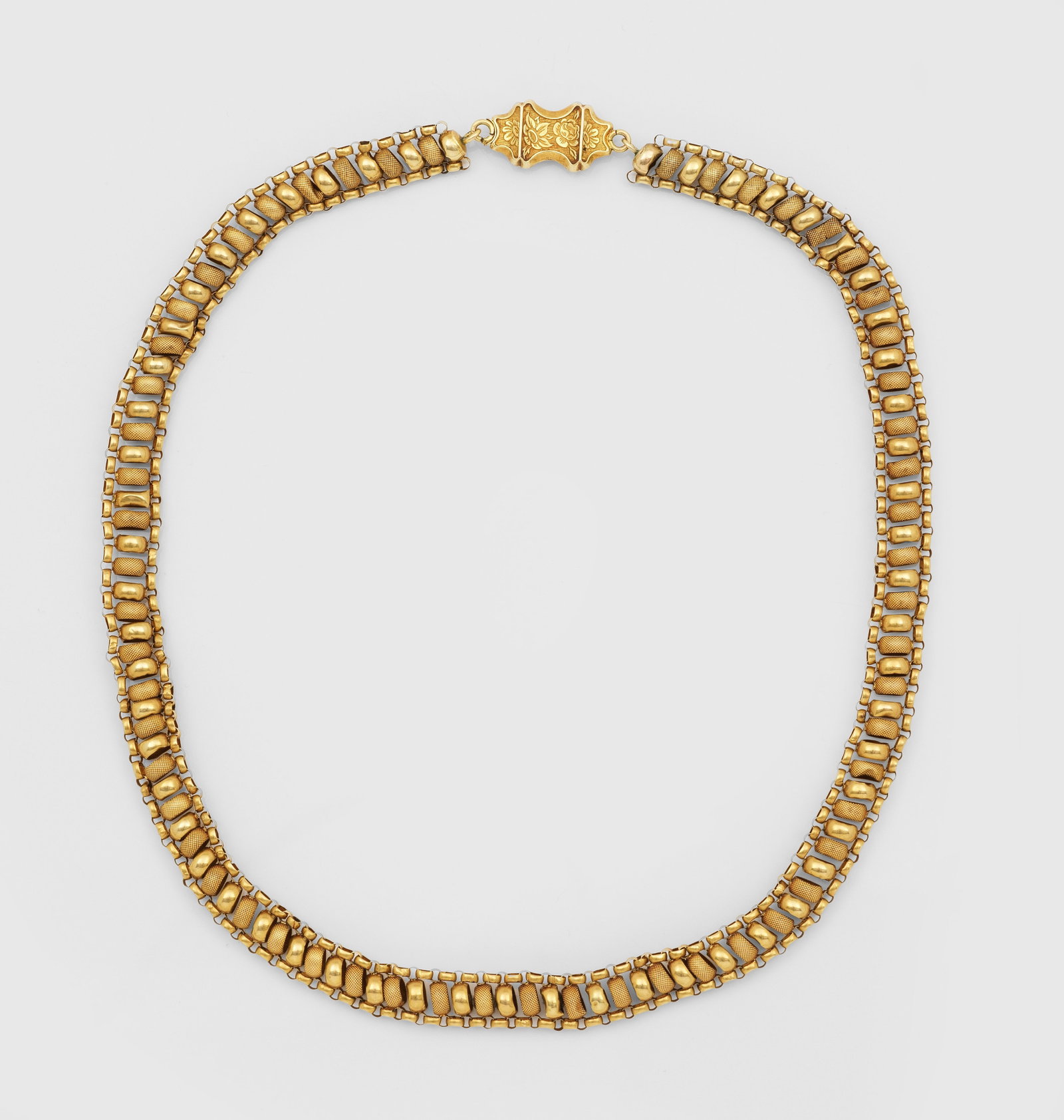 Biedermeier-Halskette, 1. Hälfte 19. Jh.: Gelbgold, 14 ct.; Breites sog. Bandeau aus fein geriffelten sowie polierten Rundgliedern, balusterartige Schließe mit erhabenem, floralen Dekor. Gew. ca. 16,49 g. Biedermeier necklace from the first 