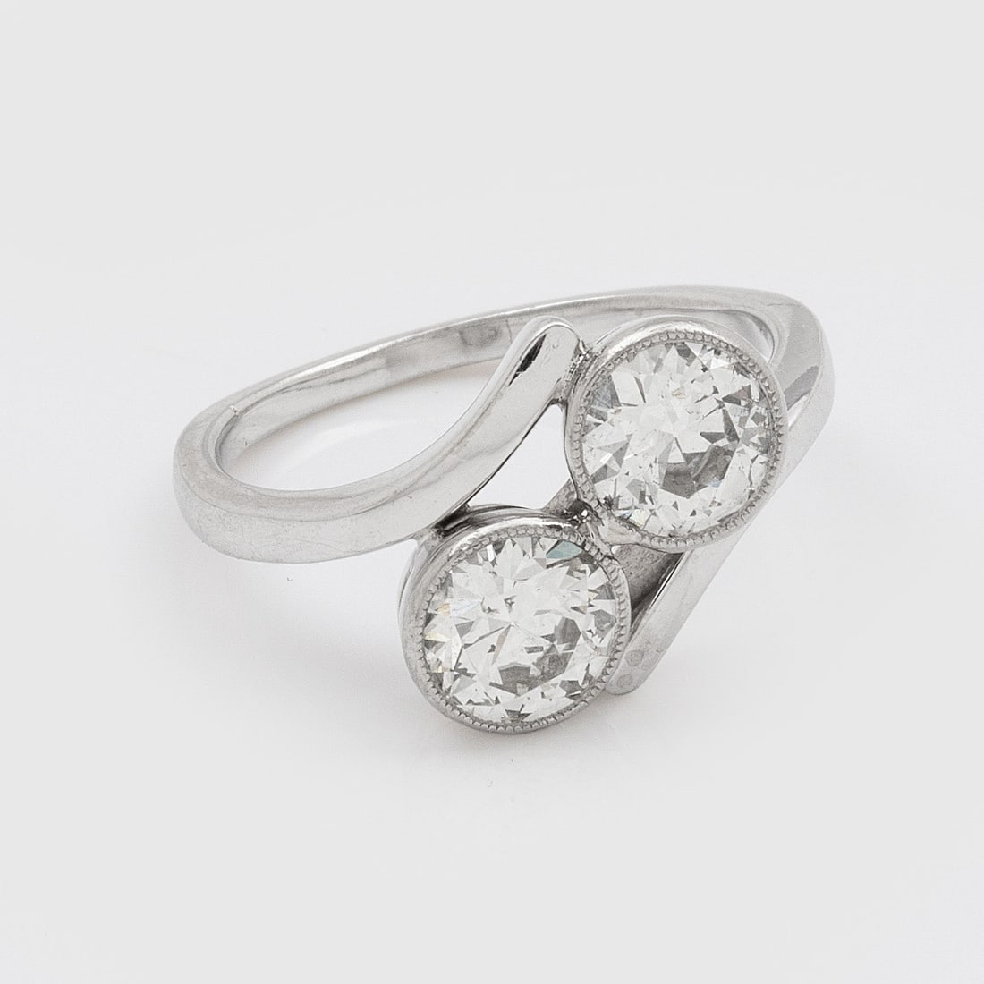 Moi & Toi-Diamantring: 18 ct. Weißgold. Diagonal verlaufende Ringschiene besetzt mit 2 Altschliffdiamanten von zus. ca. 1,80 ct., umzogen von feinen Millgriffbändern. Gew. ca. 5,33 g. Ring set with two diamonds approx.