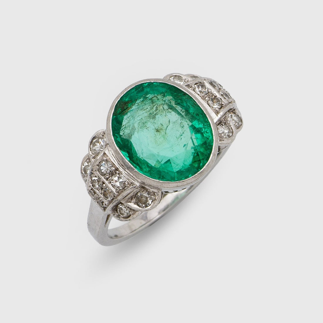 Kolumbianischer Smaragdring: Weißgold, 18 ct.;. Zentral besetzt mit leuchtendgrünem Smaragd von ca. 5,00 ct. im Ovalschliff, flankiert von 8/8 Diamanten. Gew. ca. 8,24 g. Ring set with Columbian emerald approx. 5,00 ct. and