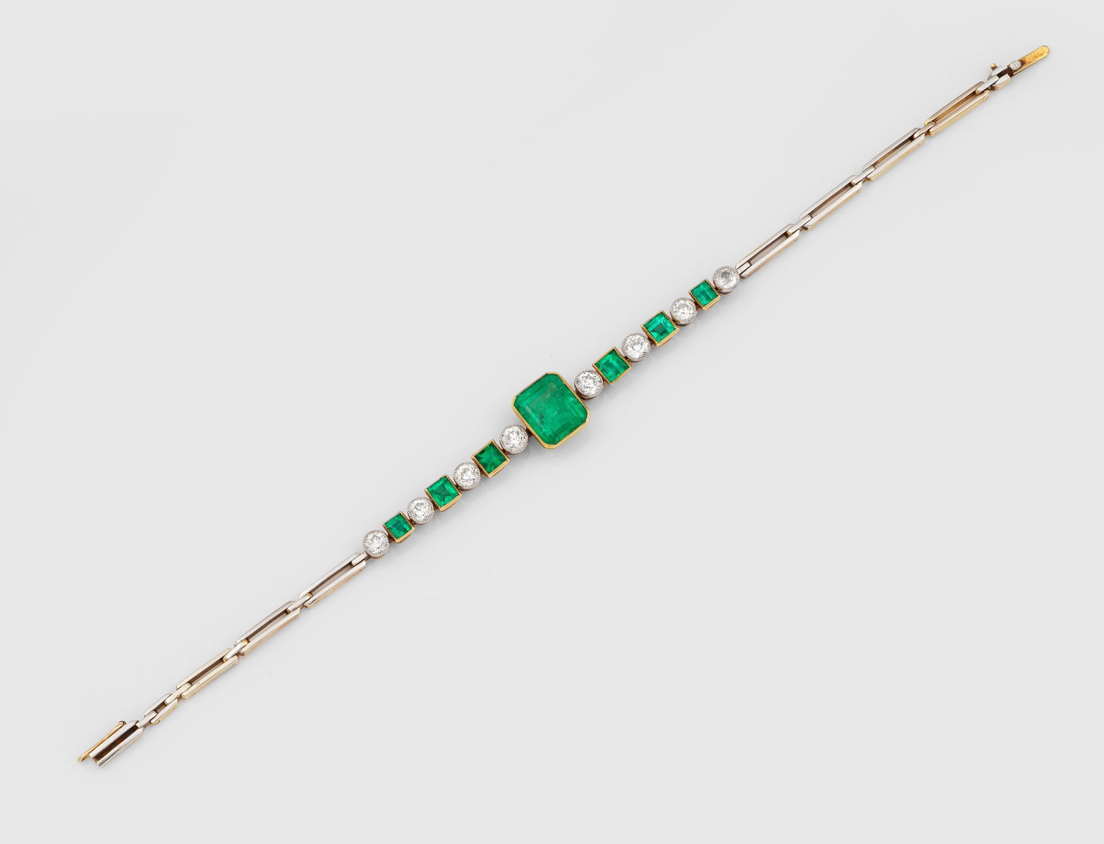 Art Déco Smaragd-Diamant-Armband: Weißgold, 14 ct.; Zentral besetzt mit einem leuchtendgrünen Smaragd von ca. 2,50 ct., flankiert von korrespondierenden Smaragden von zus. ca. 0,90 ct., unterteilt durch Altschliffdiamnten von zus.