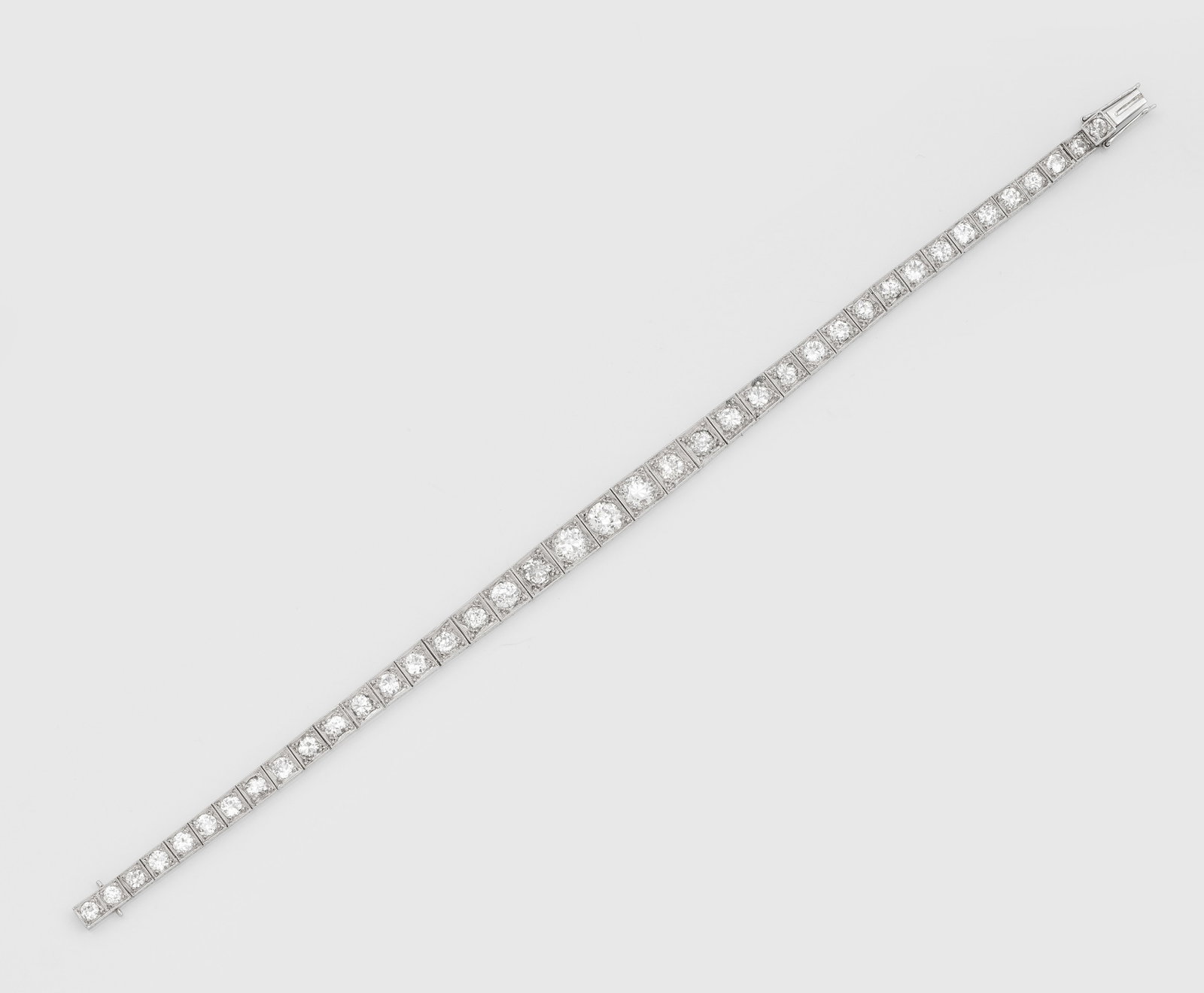 Art Déco-Diamantarmband: Platin. Linear im leichten Verlauf besetzt mit Altschliffdiamanten von zus. ca. 9,40 ct. (I-J/vs-si). Gew. ca. 14,42 g. Beiliegend Versicherungsgutachten von 1976, DM 14.500,-. Juwelier ROESSNER, Hamb
