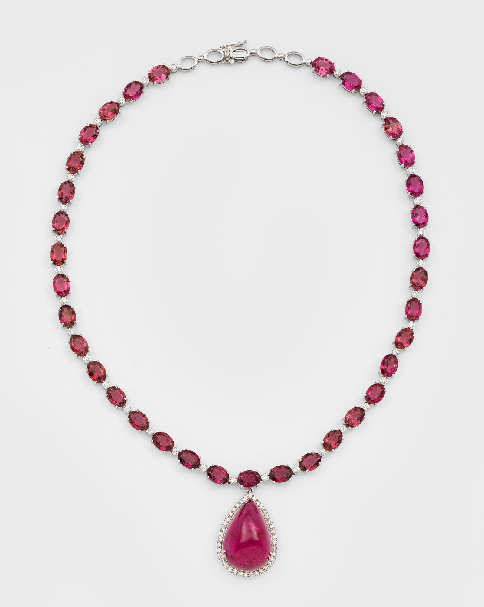 Repräsentatives Turmalin-Collier: Weißgold, gest. 585 ct.; Collierkette umlaufend besetzt mit rosafarbenen Turmalinen im Ovalschliff, zentral tropfenförmiger Anhänger mit großem Turmalin-Cabochon, inges. Turmaline von zus. ca. 76,
