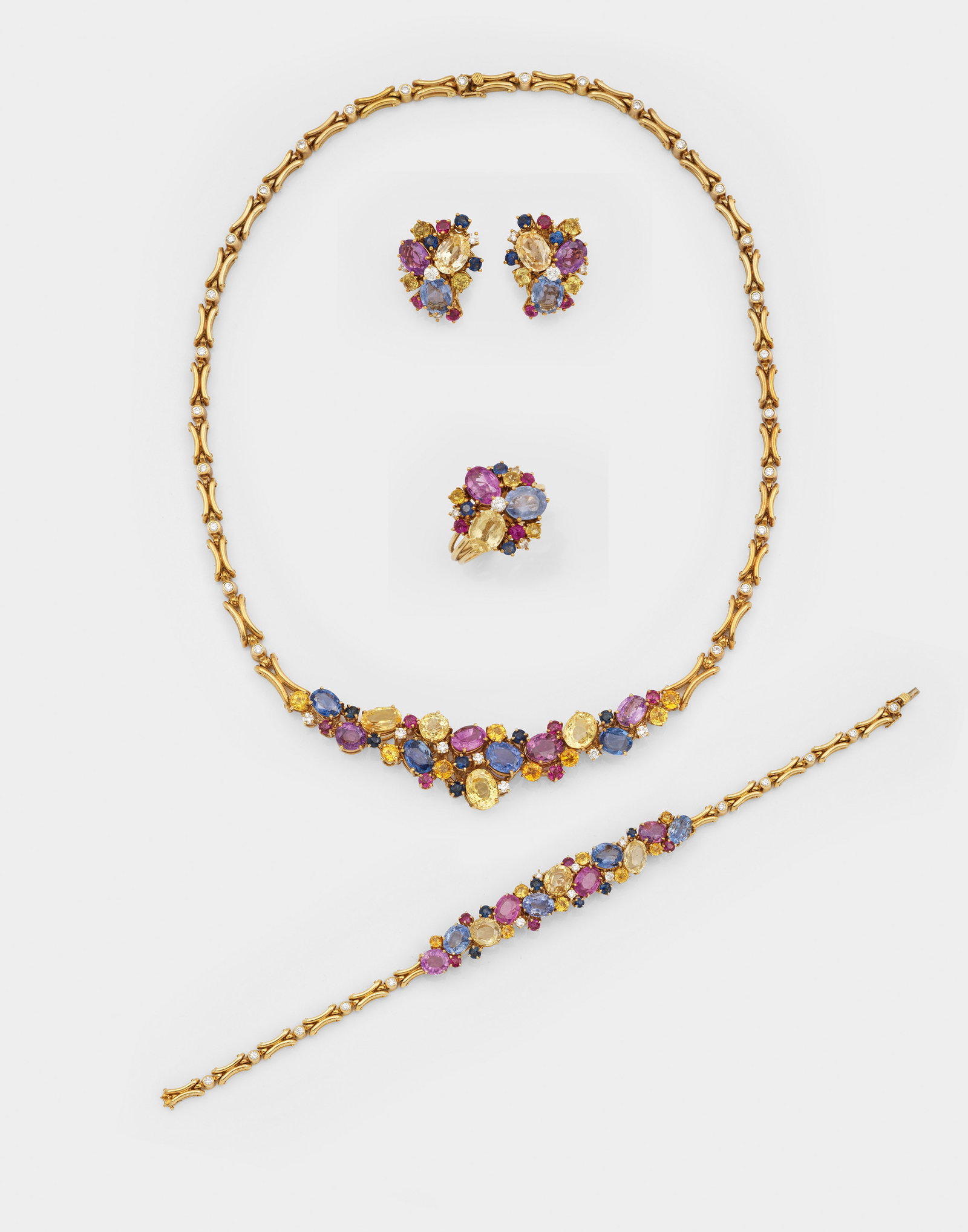 Charmantes Harlequin-Saphir-Parure: Gelbgold, gest. 750. Collier, korrespondierende Ohrclips, Ring und Armband. Besetzt mit Saphiren in den Farben Pink, Gelb, Blau von zus. ca. 30 ct., akzentuiert durch kleinen Diamanten. Ges.-Gew. 94,4