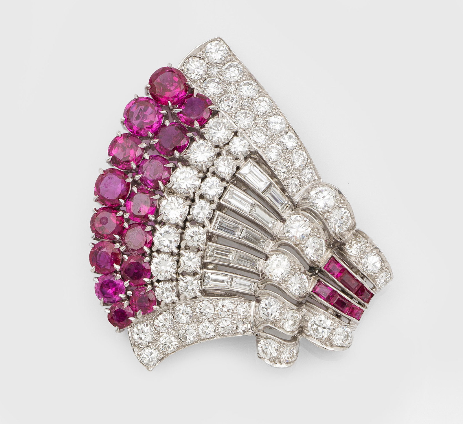 Glamouröse Art Déco Rubin-Diamant-Clip-Brosche: Platin. Fächerartig gestaltet, schauseitig besetzt mit taubenblutroten Rubinen von zus. ca. 2,80 ct., Brillanten und Diamant-Baguetten von zus. ca. 2,70 ct. (F-G/vs). Gew. ca. 15,40 g. brooch set wit