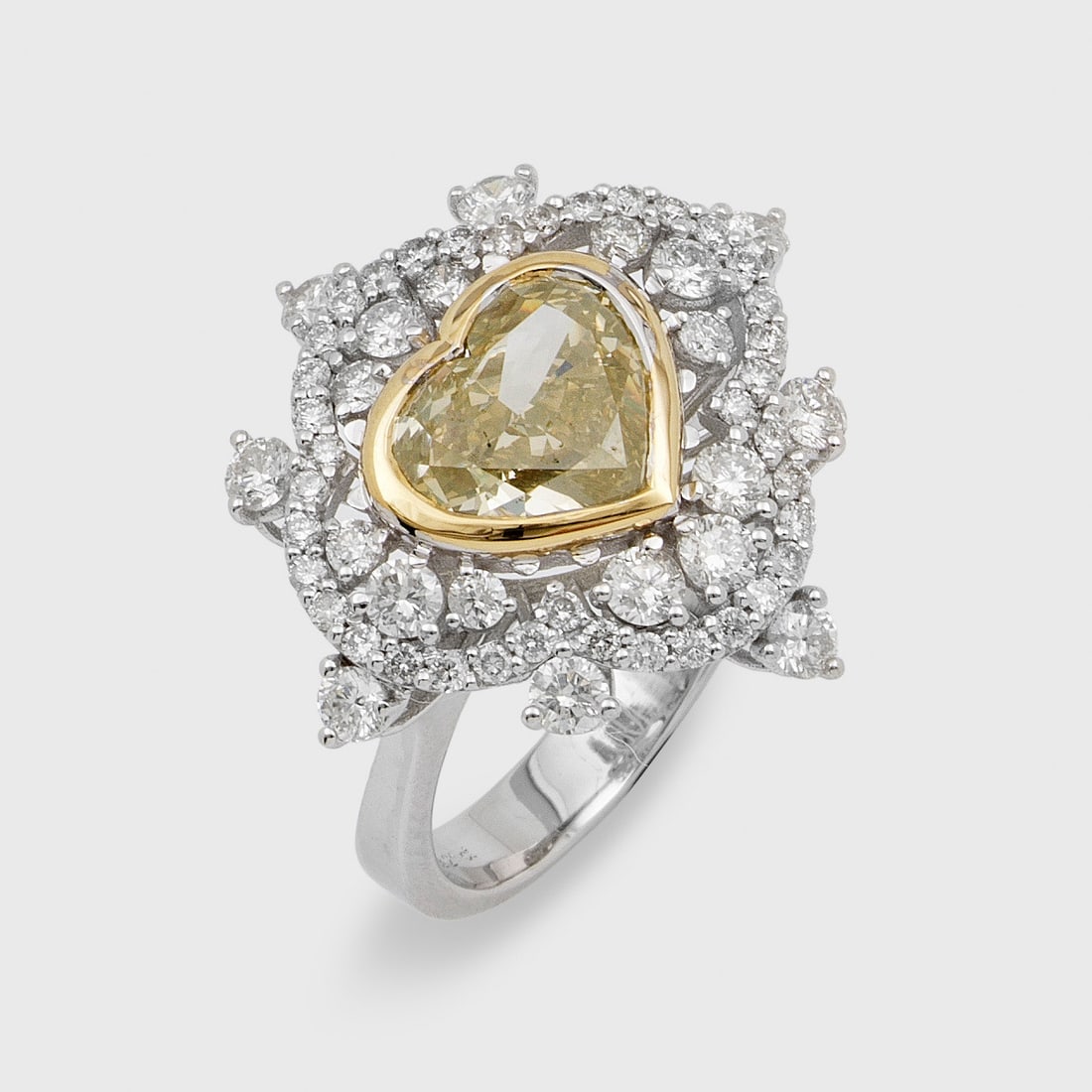 Glamouröser Fancy-Diamantring: Weißgold, gest. 750. Zentral besetzt mit einem Fancy Light Yellow-Diamanten von ca. 3,21 ct. im Herzschliff, entouriert von Brillanten von zus. ca. 1,32 ct.; Gew. ca. 7,71 g. Beiliegend Expertise. Ri