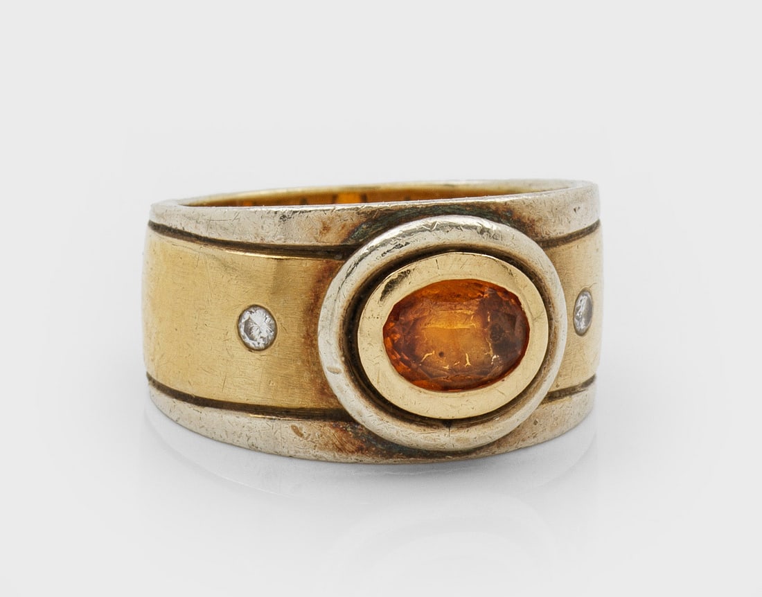 Moderner Bandring mit Madeira-Citrin und Brillanten: Gelb- und Weißgold, gest. 18 ct.; Breite Bandringschiene, zentral besetzt mit einem Madeira-Citrin von ca. 0,75 ct., flankiert von Brillanten von zus. ca. 0,10 ct.; Gew. ca. 14,32 g. Ring set with an